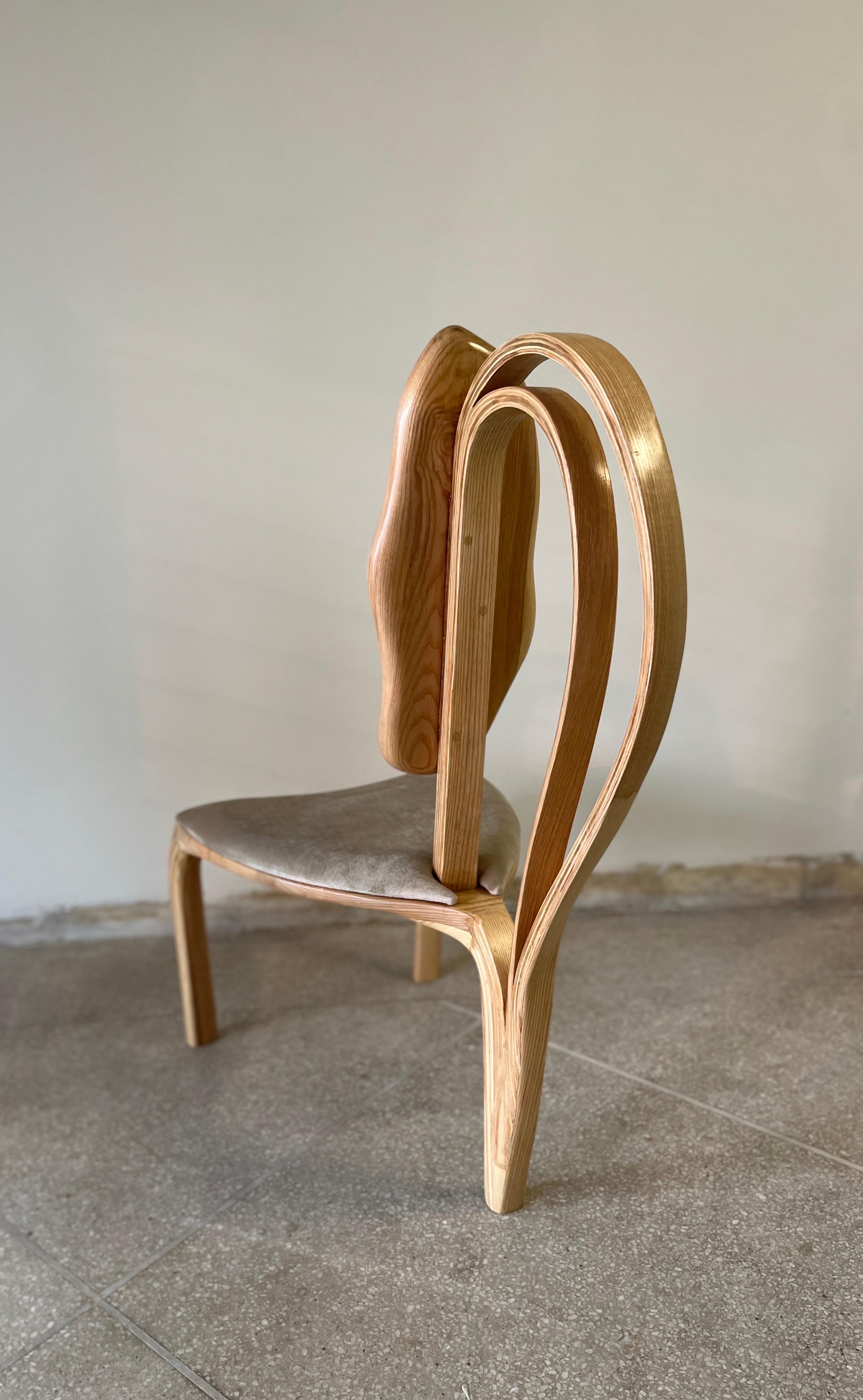 This is the Dining Chair No. 1 of the Fluentum Series of works. 

The Dining Chair No.1  has a free-form design; the wood bends and curves with beautiful flows to create the design. The handcrafted details on the piece such as the curves, varying