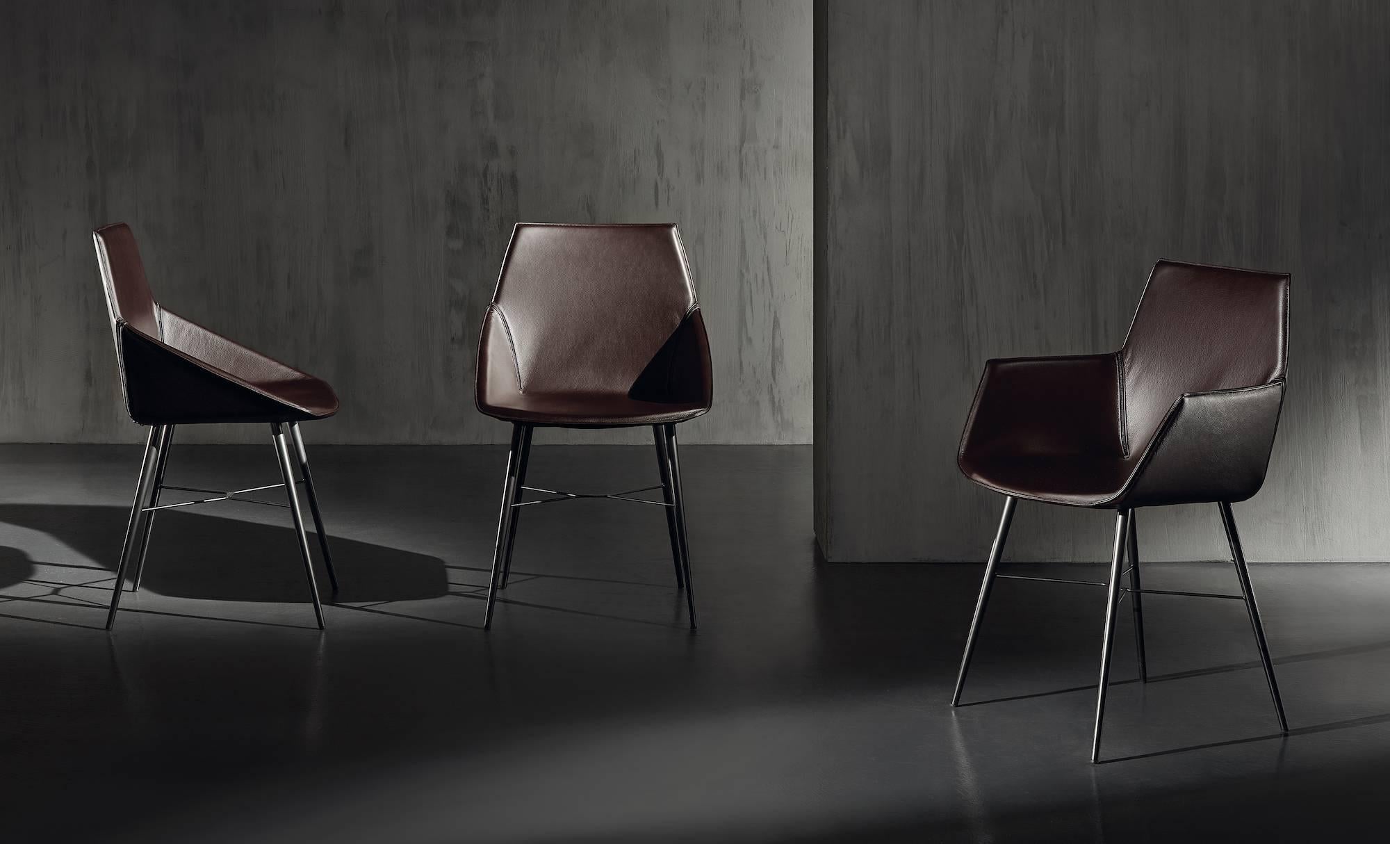 A contemporary leather seat of minimal design and elegant proportions, with a chrome-plated or burnished metal base. Chair with thermo-folded shell, particularly light, flexible and comfortable, completely coated with fabric, felt or leather. The