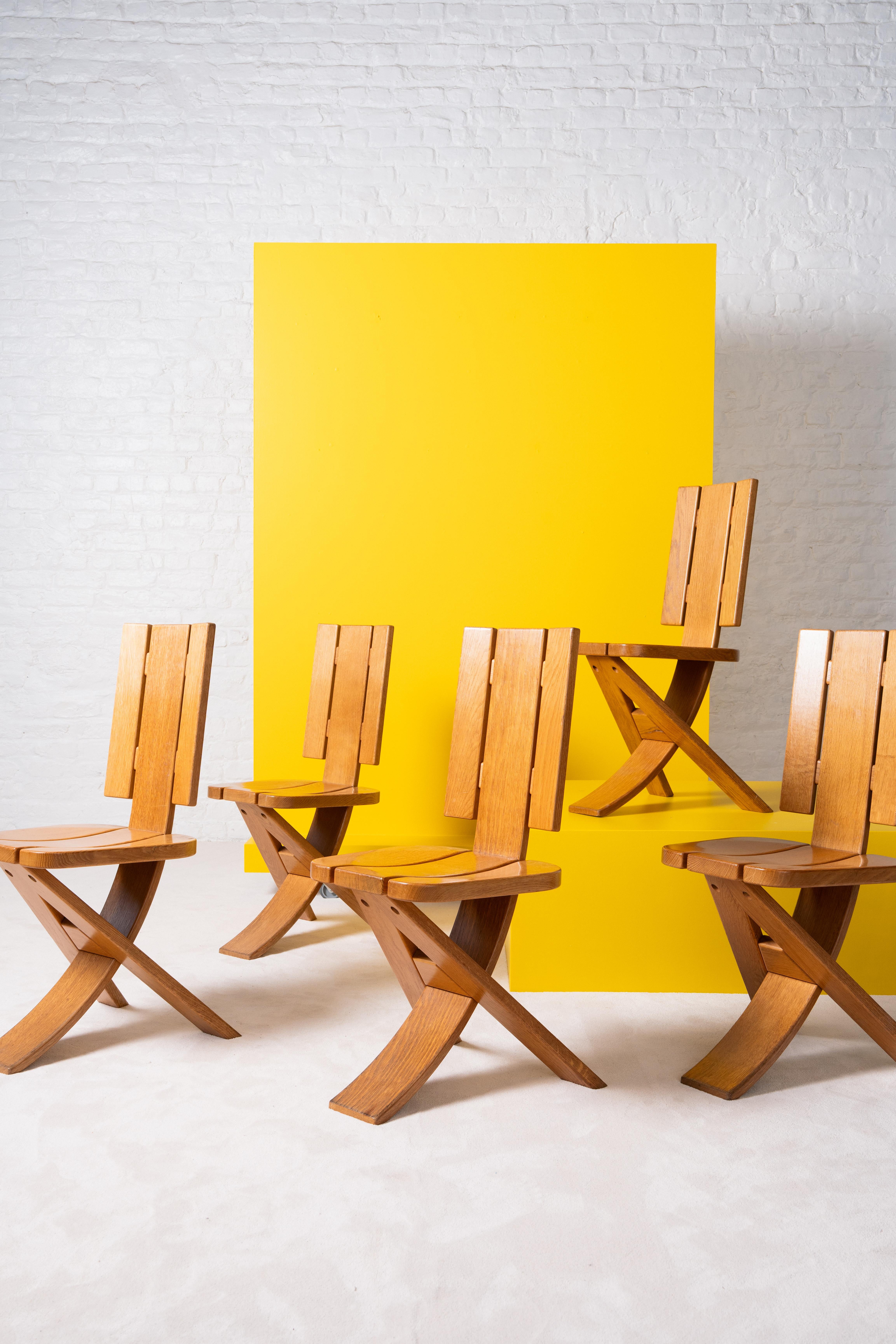 Set of five sculptural solid oak dining chairs, produced by Ebénisterie Seltz in the 1970s. Featuring a bold three-legged construction and curved backrest. The wood shows a warm, natural patina. A rare and expressive set with strong presence.