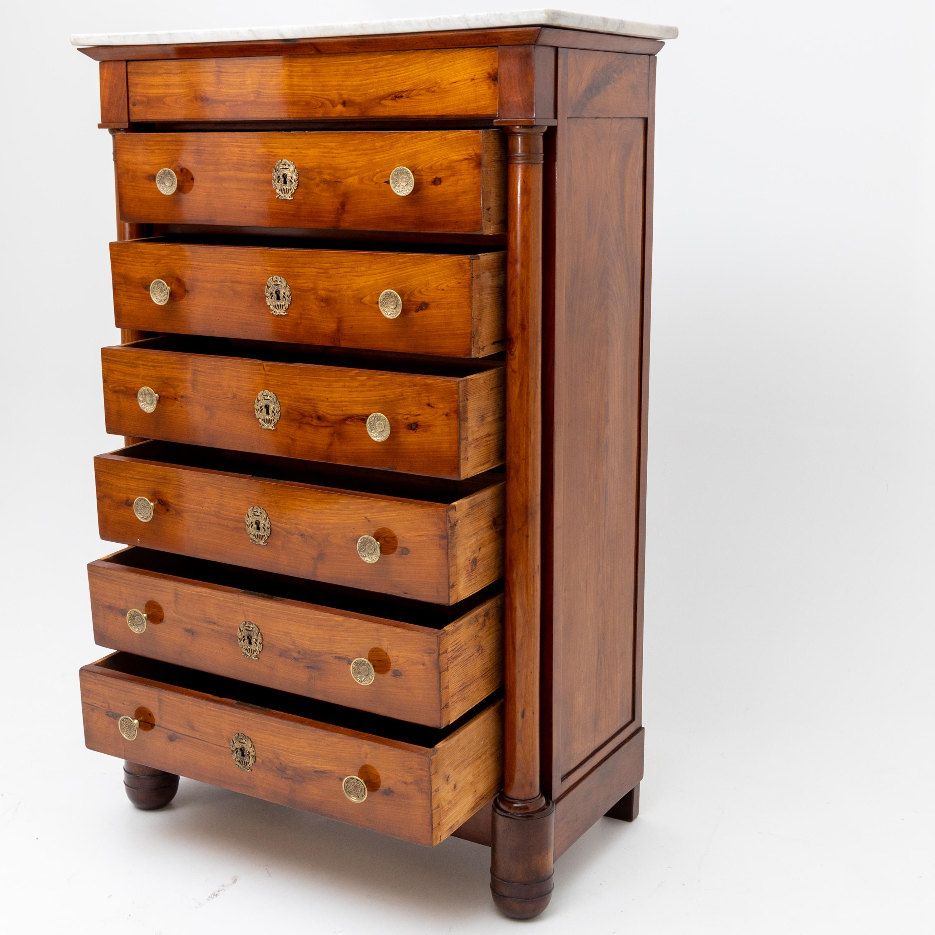 High chest or semainiere with seven drawers, marble top, brass handles and columns.