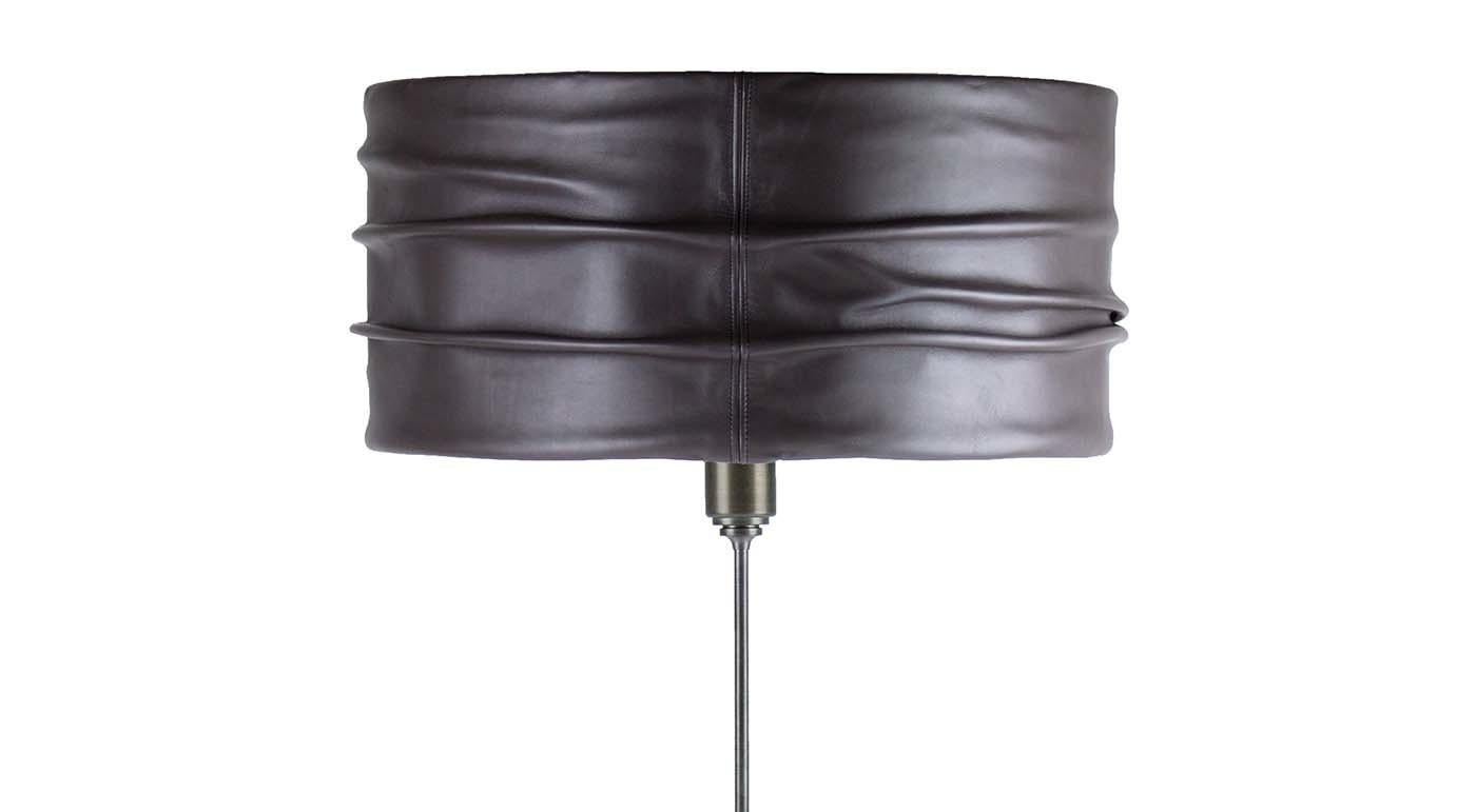 Fashioned of steel with a dark, matte finish and showcasing an elegant combination of soft and hard materials, this table lamp is an impeccable piece of decor that will imbue any room with a chic, Industrial-inspired flair. The circular base is of