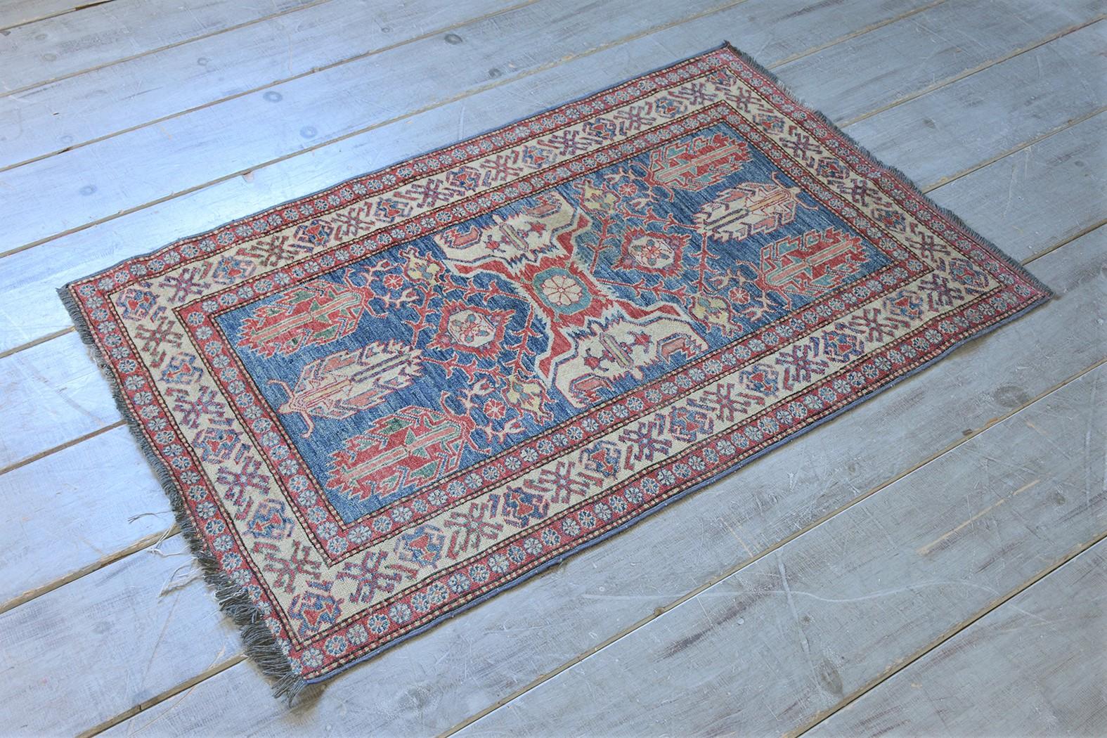 Elevate your living space with our extraordinary semi-antique carpet rug, crafted from wool and in excellent condition. This remarkable vintage rug draws the eye with its intricate asymmetrical design and vivid color palette featuring blue, red, and