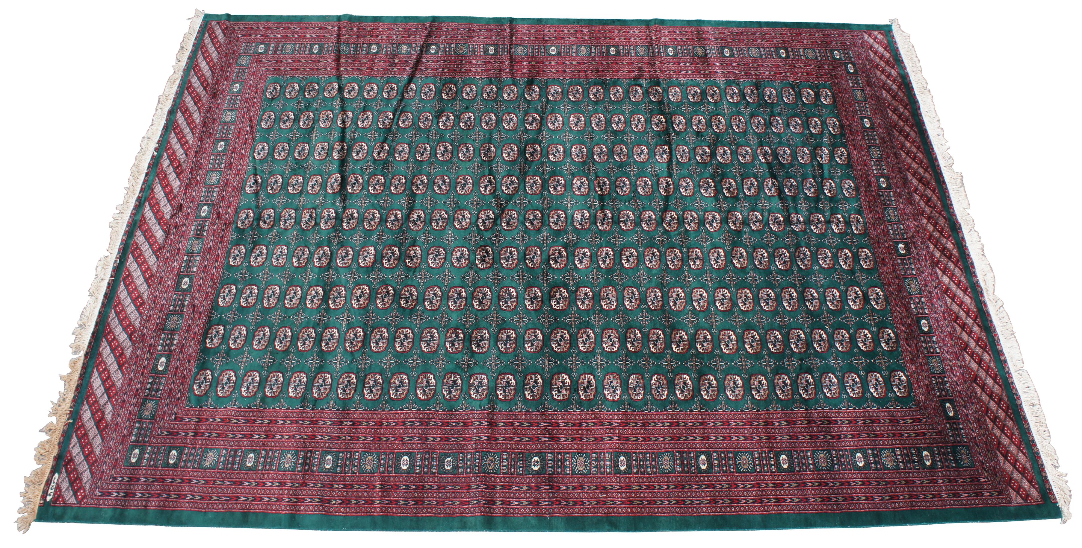 Exquisite Pakistani royal Bokhara signed wool area rug. Emerald green with reds and whites. Intricately detailed with a layered switchback pattern.