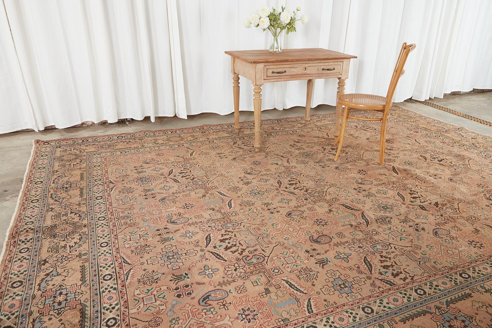 Mesmerizing semi-antique Persian hand-knotted wool Tabriz rug made in the decorative art nouveau taste. The rug features natural foliate designs with sinuous patterns and floral sprays over a rose taupe ground. Beautifully crafted with vibrant