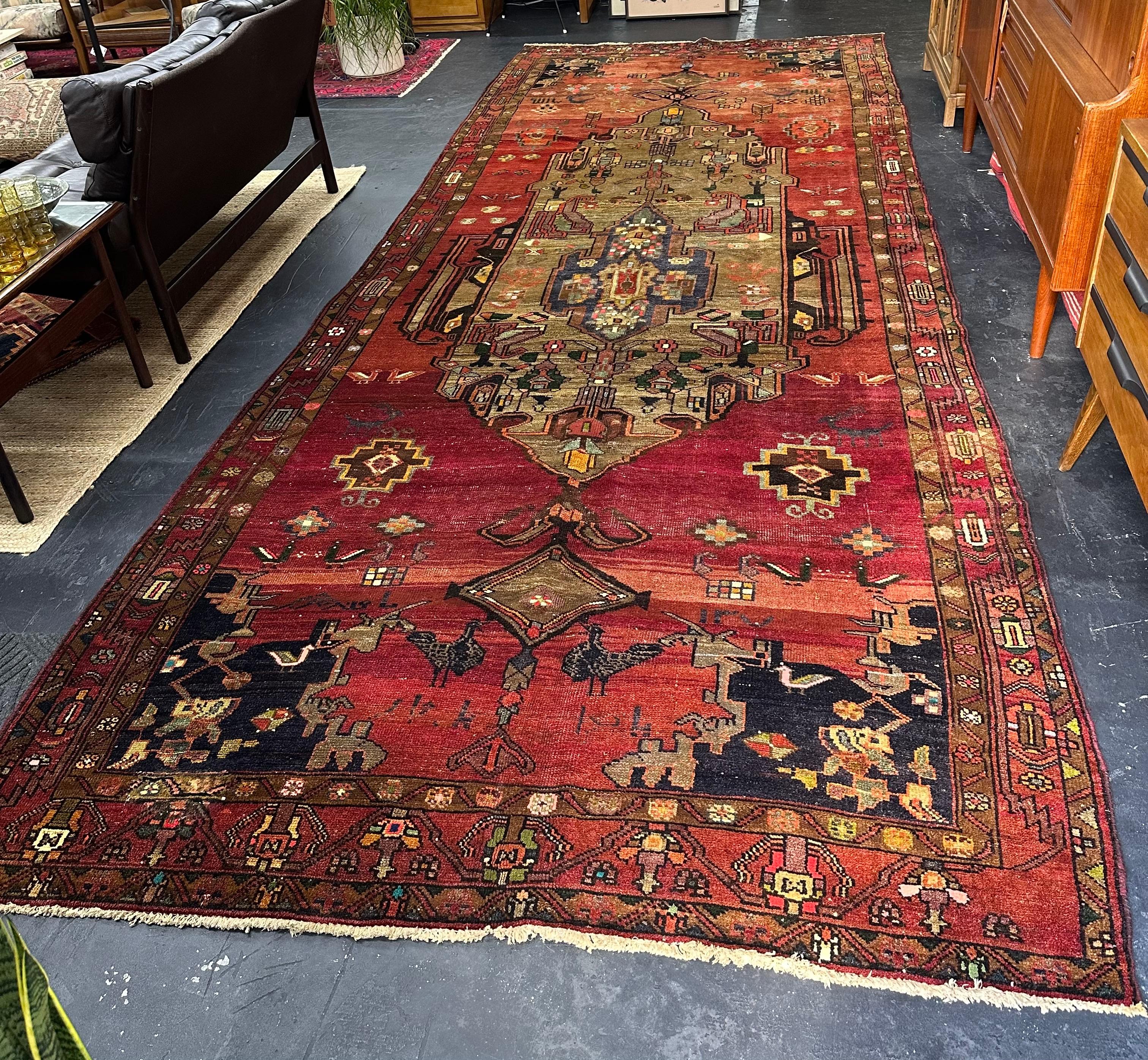 Grande e imponente runner persiano semi-antico di 16,10' x 6,5'. Lana annodata a mano nei toni del pesca, dell'arancio e del rosso con accenti di verde acqua, nero, taupe, verde e giallo. Disegno floreale geometrico astratto con un grazioso