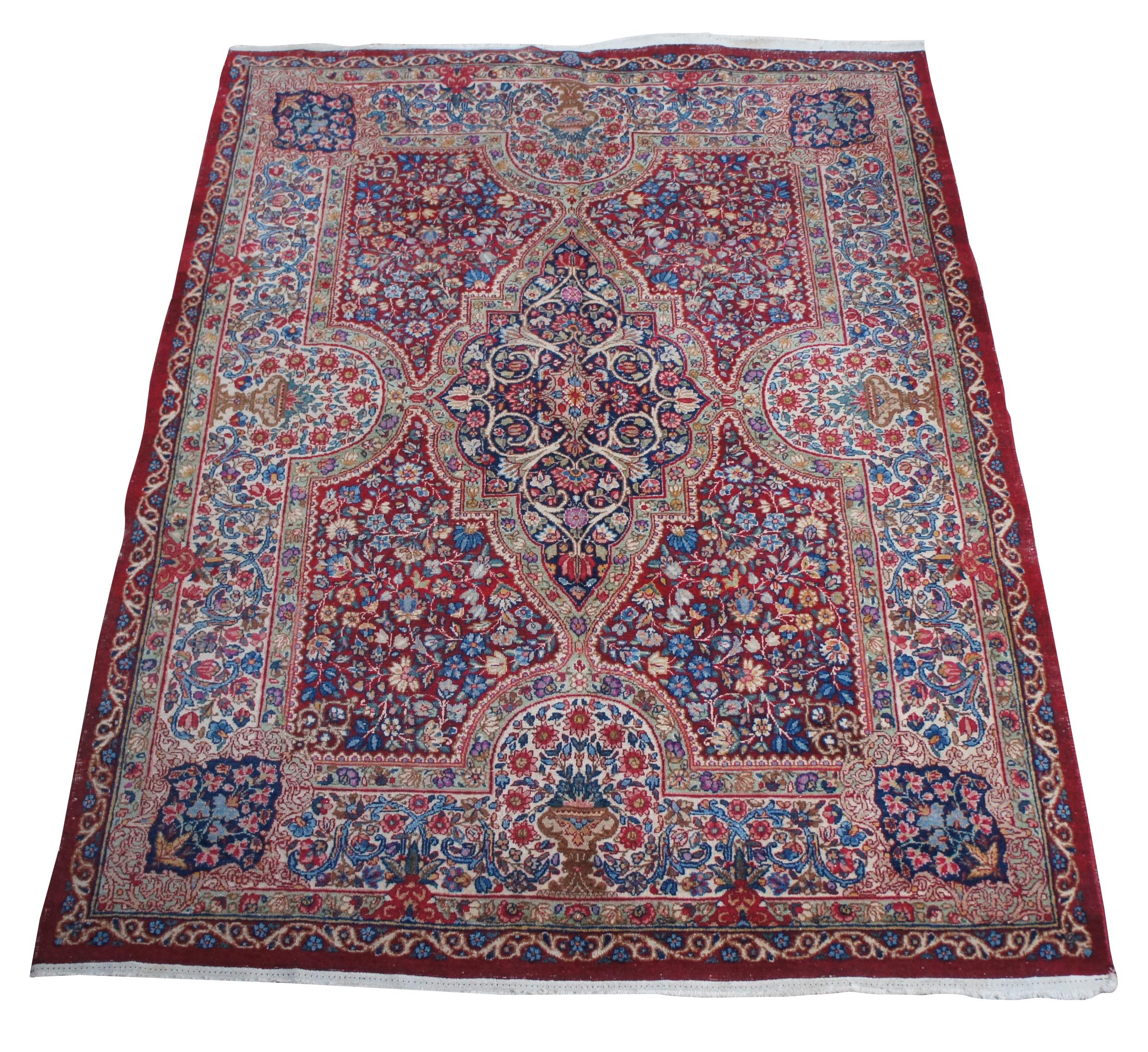 An amazing handmade Kerman area rug made in SE Persian, circa 1940-50s. Features a red base with a colorful geometric field of flowers. Includes a bouquet along each straight flanked by pendeloques along the corners. The color combinations combined