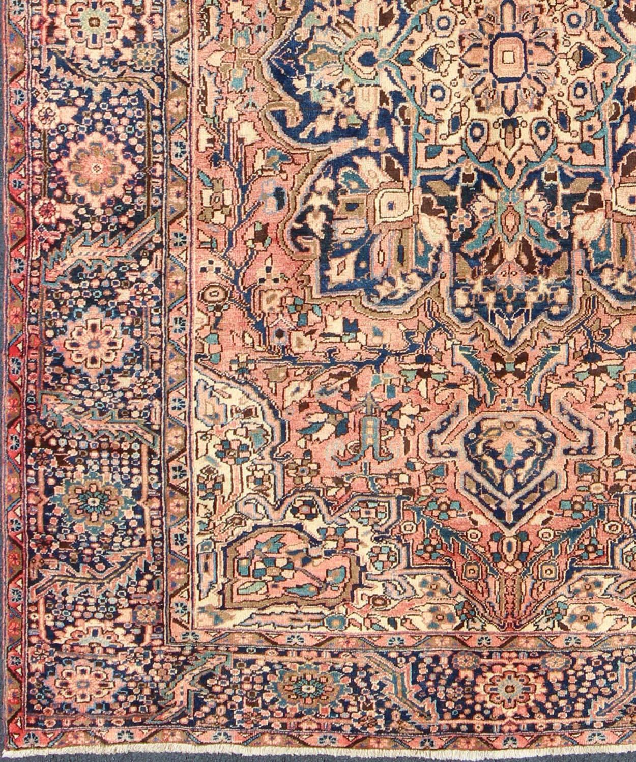 Vintage Persian Heriz rug with geometric medallion in Salmon and Royal blue, rug h-501-35, country of origin / type: Iran / Heriz, circa 1960.

This magnificent vintage Persian Heriz carpet from the mid-20th century (circa 1960) bears an exquisite