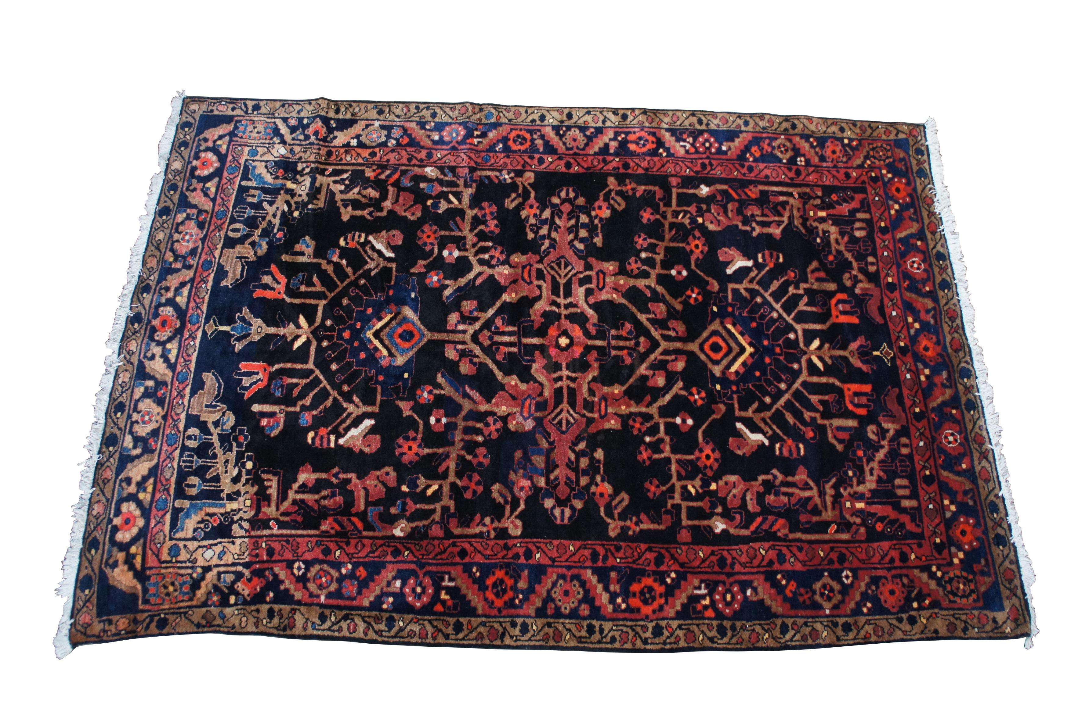 Tappeto persiano d'epoca dell'Iran Hamadan.  Realizzato in lana con un motivo floreale tribale a forma di vite con un campo scuro in contrasto con i rossi e i blu.  169 nodi per pollice quadrato.  Rossi, rosa, blu, blu scuro, bianco/beige, marrone,