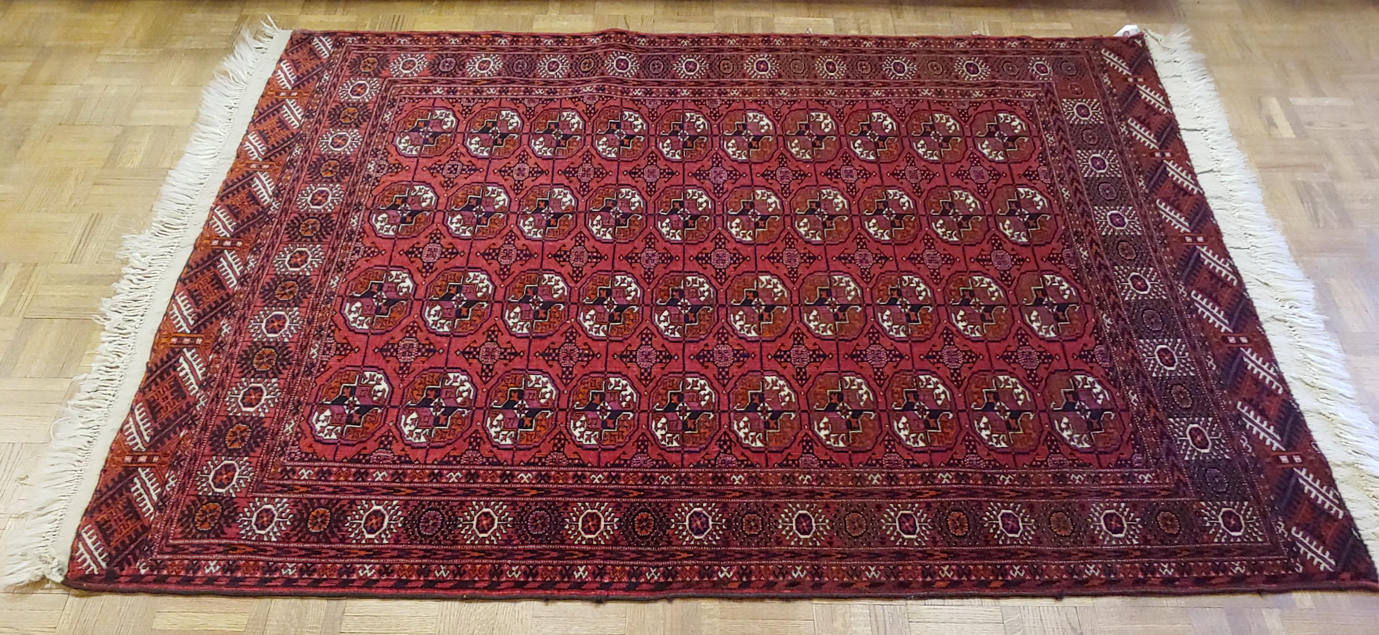 This beautiful Bohkara rug, also spelled Bukhara, is from the Turkmenistan region. They are well known for their traditional red background all-over designs. The Bohkara design is sometimes referred to as the elephant foot pattern. This rug is very