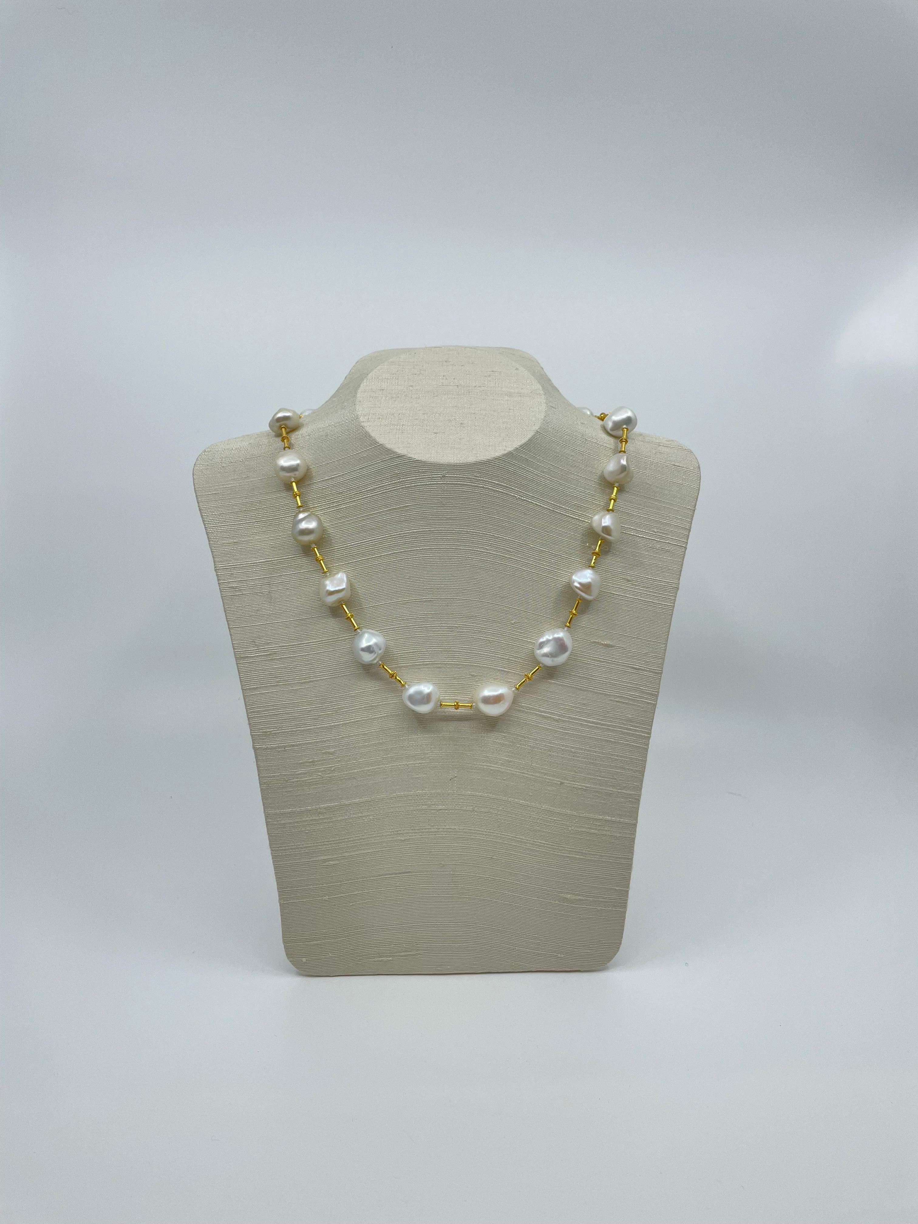 A statement necklace, the organic-formed semi baroque freshwater pearls are spaced by 18k gold tube-shaped gold beads and closes with an 18k gold toggle clasp. The pearls give a champagne shine which makes the necklace stunning and eye-catching.