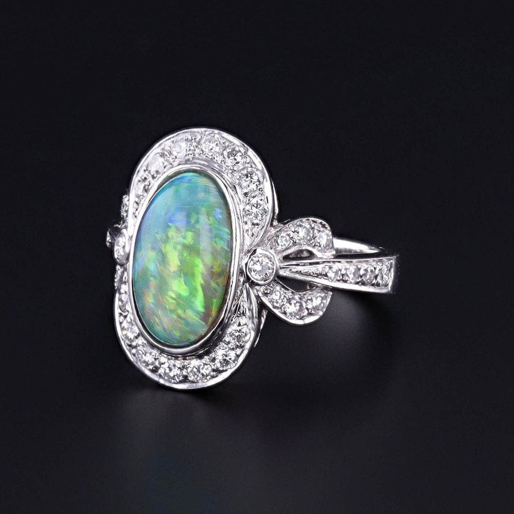 Opal and Diamond Ring: Experience the timeless beauty of this semi-black opal elegantly encased in 18k white gold and adorned with sparkling diamonds.

The face of the 1990s ring measures 0.75 inches by 0.5 inches wide, and it is in great condition.
