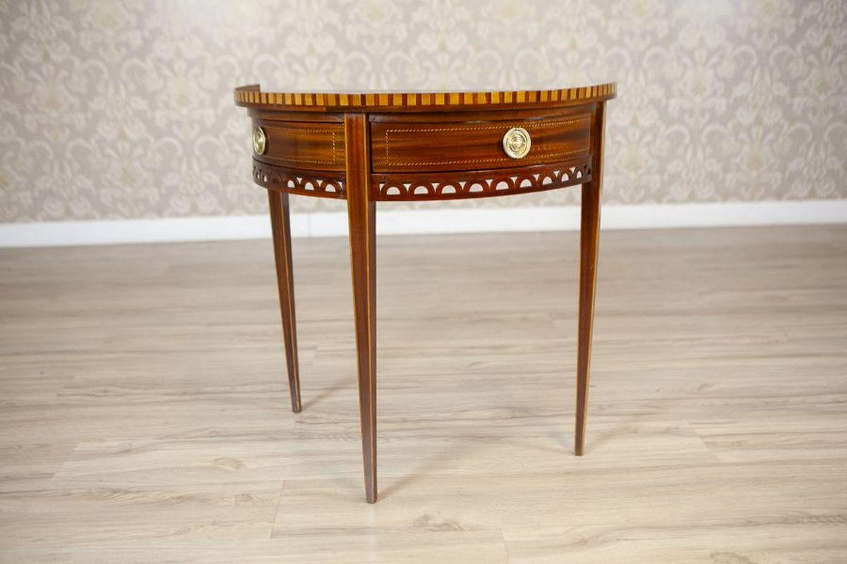 Semi-Circular Mahogany Wall Table From the Early 20th Century

A lightweight wall table made of mahogany, dating back to the early 20th century. The piece features slender, straight legs, two unusually sliding drawers, and openwork decorations on