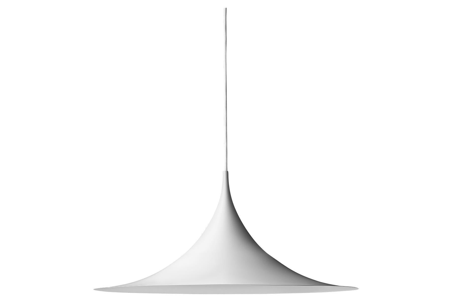 Le Semi Pendant est une lampe suspendue unique, basée sur deux quarts de cercle assemblés, dos à dos. Son abat-jour en métal émaillé en forme d'arche crée une lumière diffuse en forme de cône, idéale au-dessus d'une table à manger ou d'un plan de