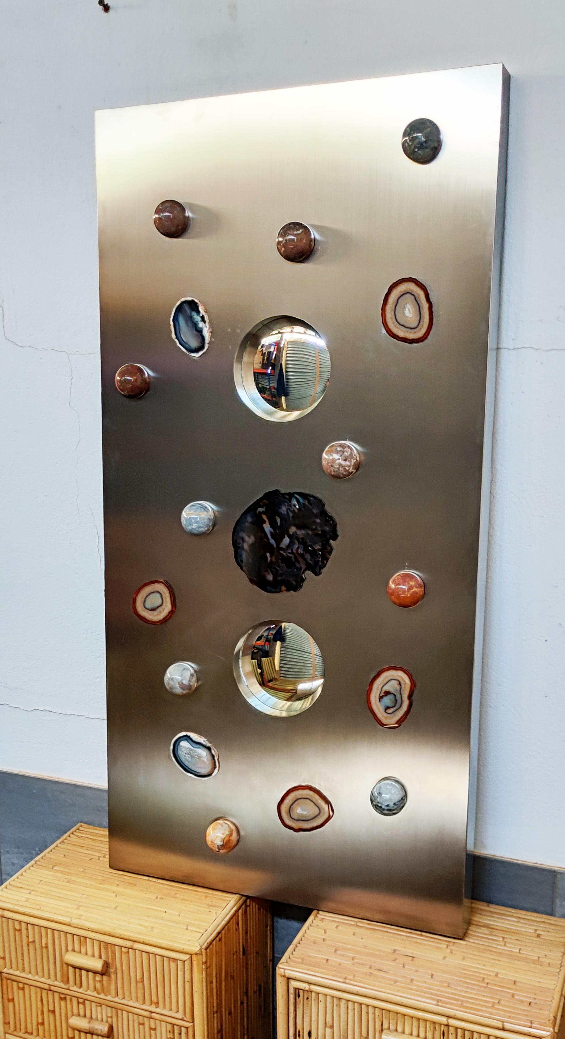Beautiful and rare semi precious stone wall sculpture with convex mirrors, attributed to Maria Pergay and manufactured in France in 1970. Incredible work on a large wooden box covered with brushed aluminum inlaid with semi-precious stone and two