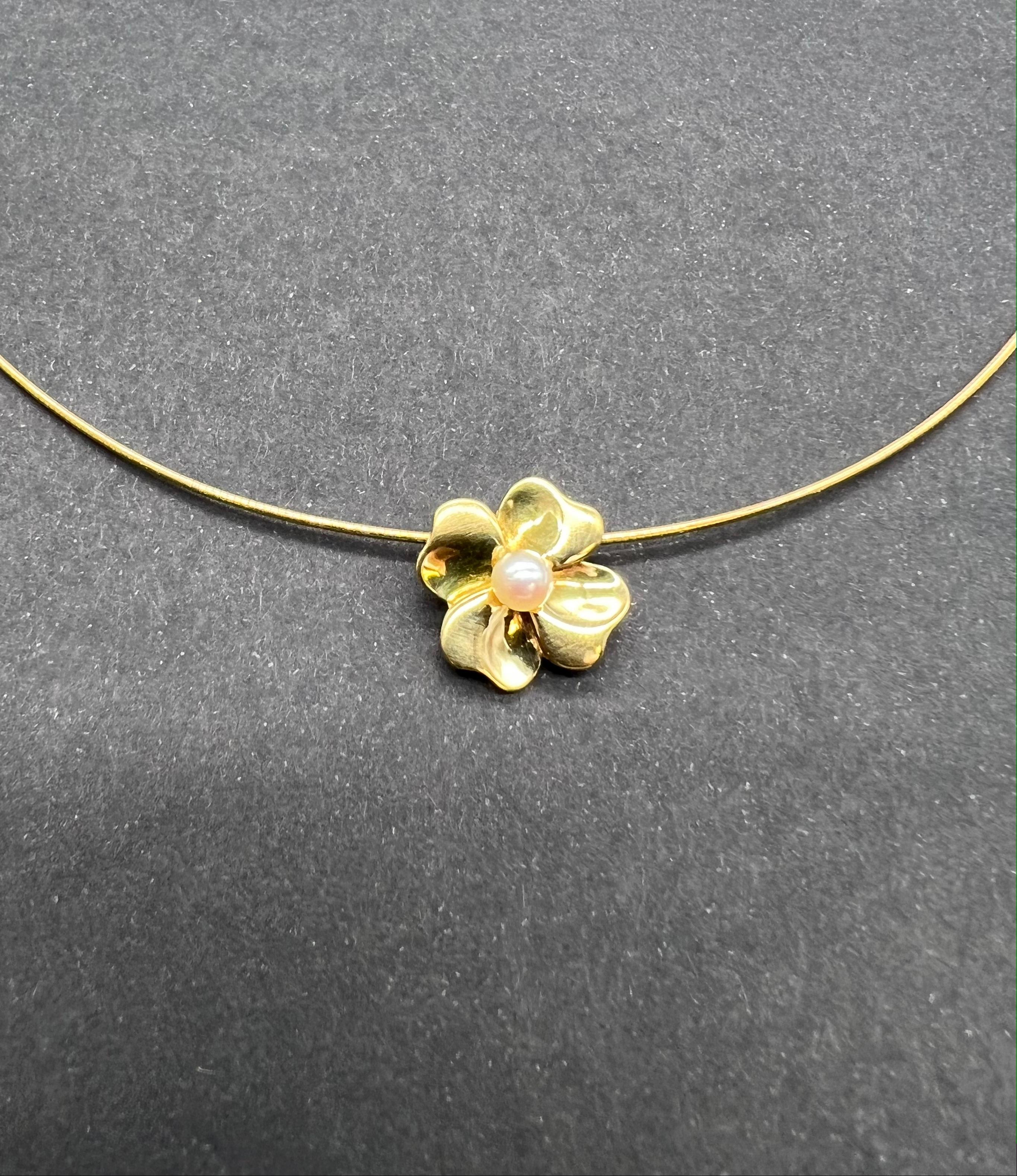 Semi-Rigid Omega Mesh Necklace with Flower Pendant and Cultured Pearl. 

Semi-rigid omega mesh necklace in 18 Carat yellow gold accompanied by a flower or 4-leaf clover pendant and surmounted by a cultured pearl. This pretty necklace from the 1980s
