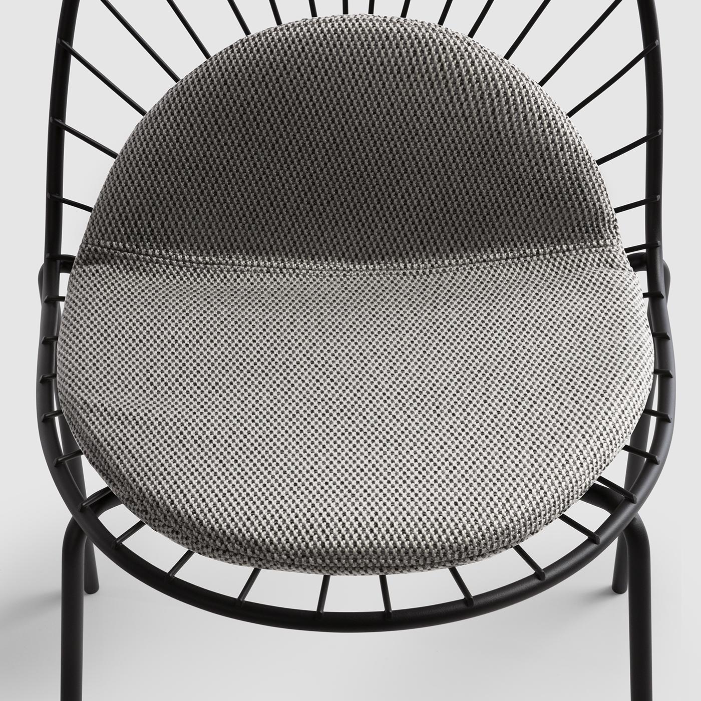 A striking showcase of refined craftsmanship, this chair is part of a series whose seats and backrests are marked by a stunning sun ray-like design crafted of tubular steel rods. This piece is completed with an indoor-outdoor removable fabric