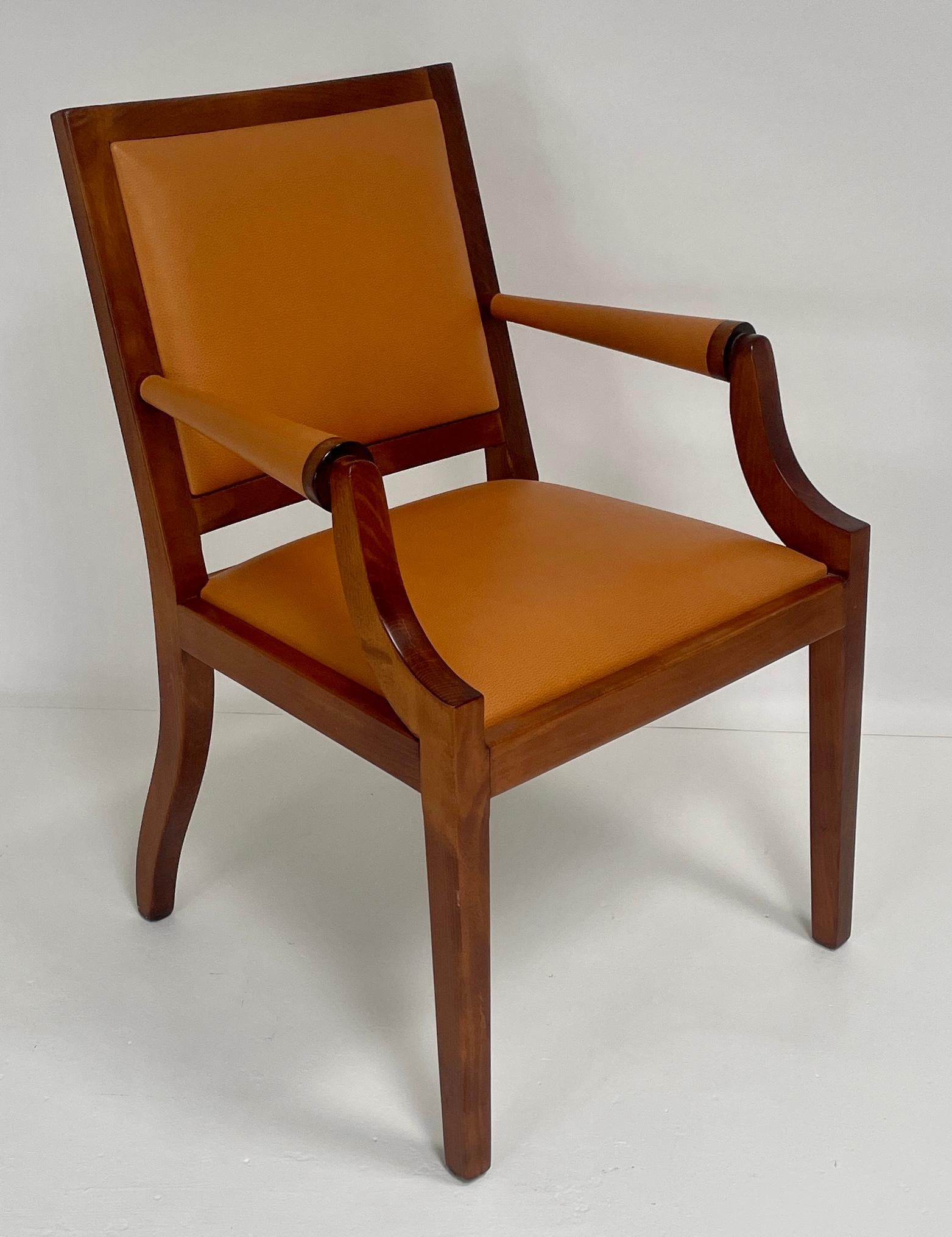 A stately arm chair. The curved lines of the alder frame have a cherry finish. The Hermes orange color leather cushions complement the finish of the frame. The details of the stitching and elegant lines create a classic comfortable arm chair.