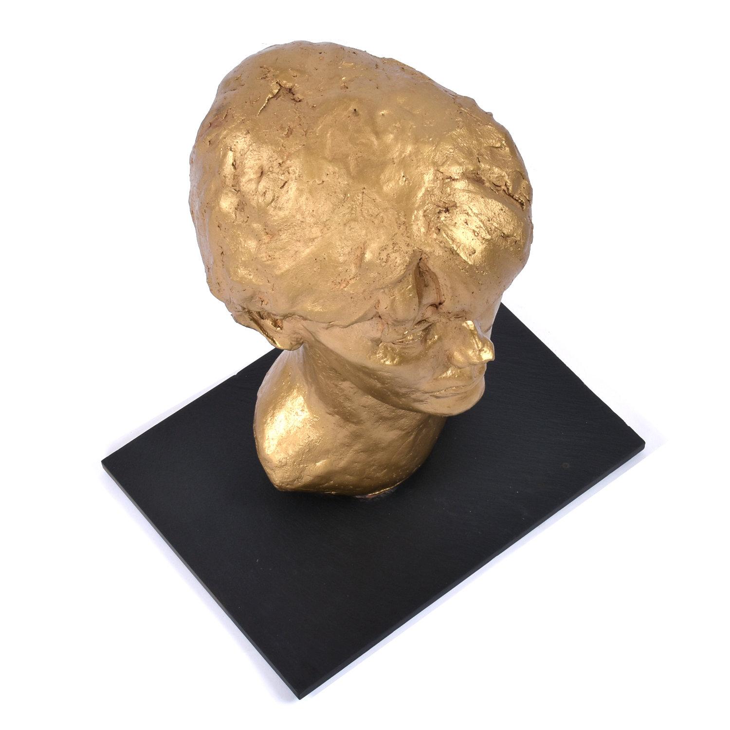 Busto de arcilla pintado en oro de niño sobre base de pizarra, firmado por Sendelbach Yeso en venta