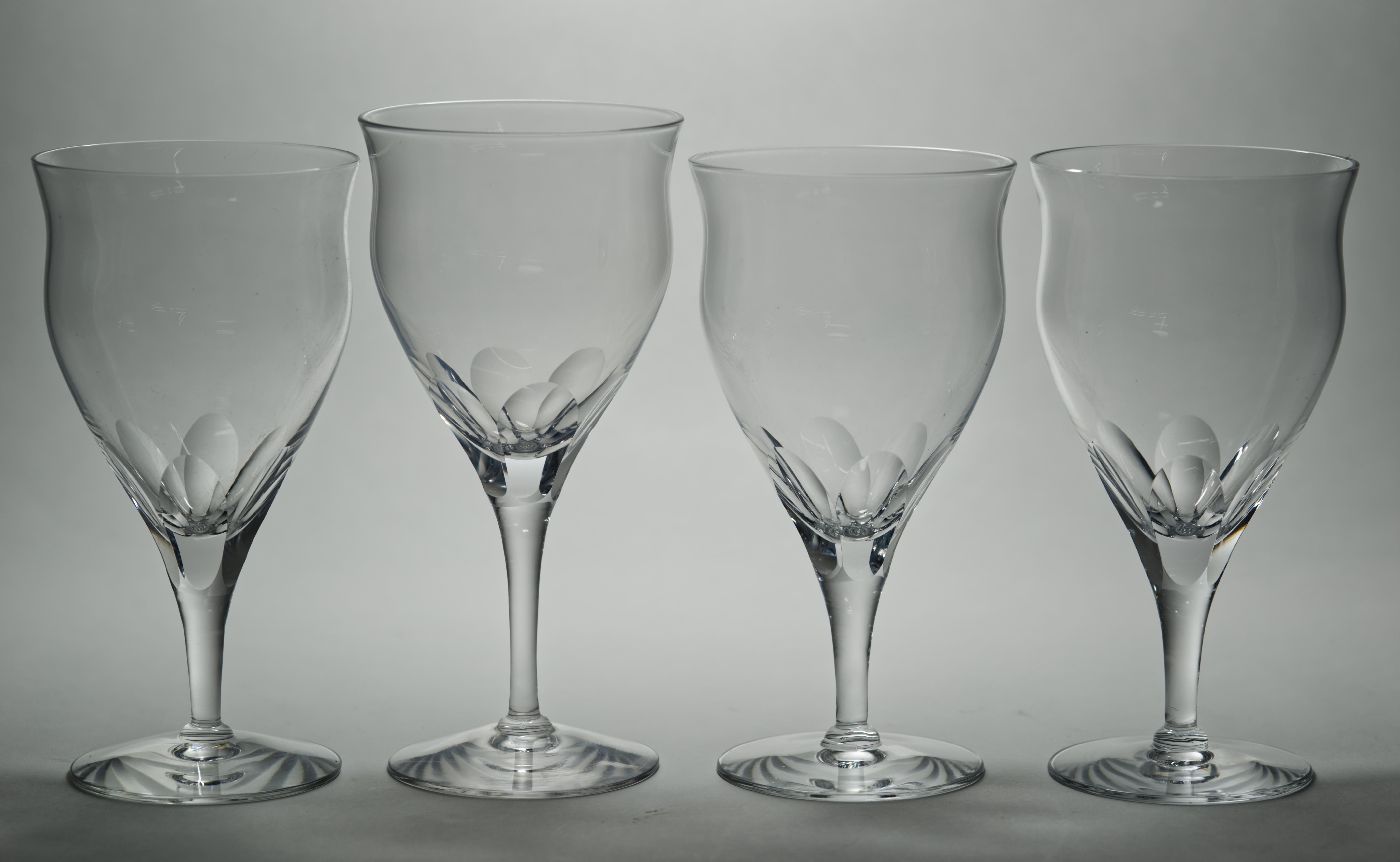  Set of 4 vintage cut crystal water goblets or glasses feature elegant, streamlined form with pronounced panel cuts starting from the top of the stem and continuing upwards, reminiscent of Moser's Papal style barware. The classic design of the