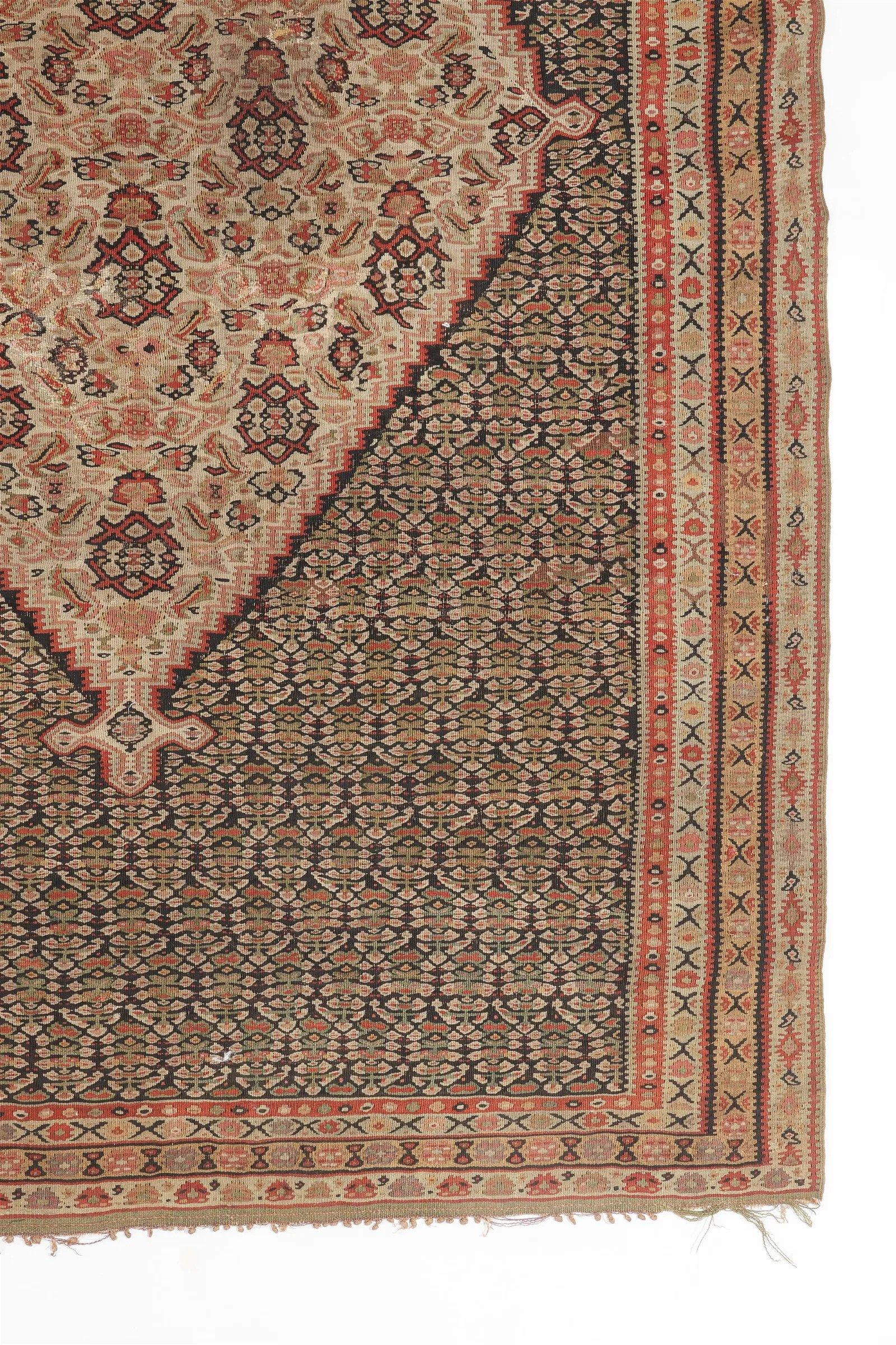 Ce Rug & Kilim en laine provient de Perse à la fin du 19e siècle. Le médaillon central est surmonté d'un délicat motif cachemire, ou 