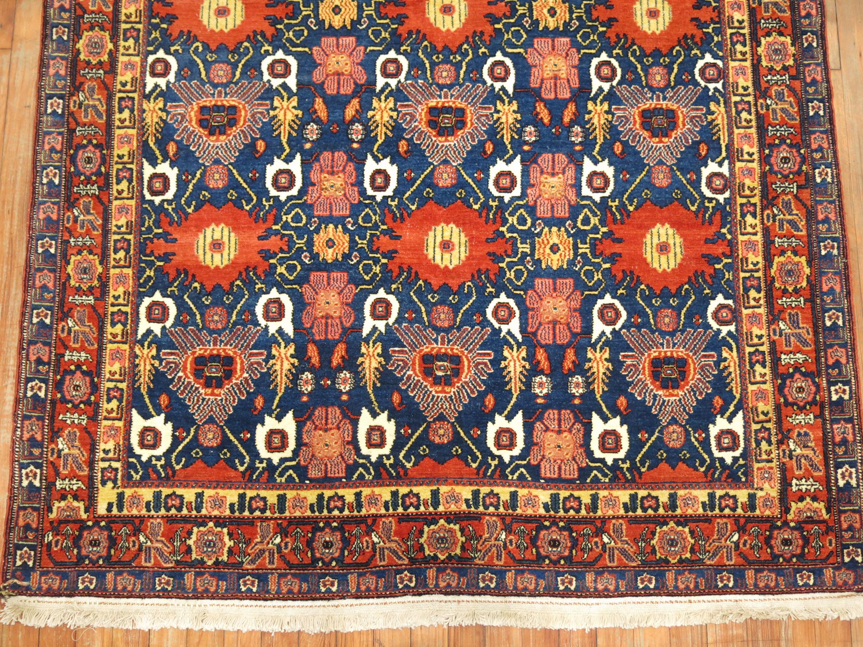 Spectacular collector level finely woven early 20th century Persian Senneh rug. This delightful intermediate size piece has overscale blossoms and a deftly dyed palette of warm and cool tones create a glowing character. Colorizing the alluring