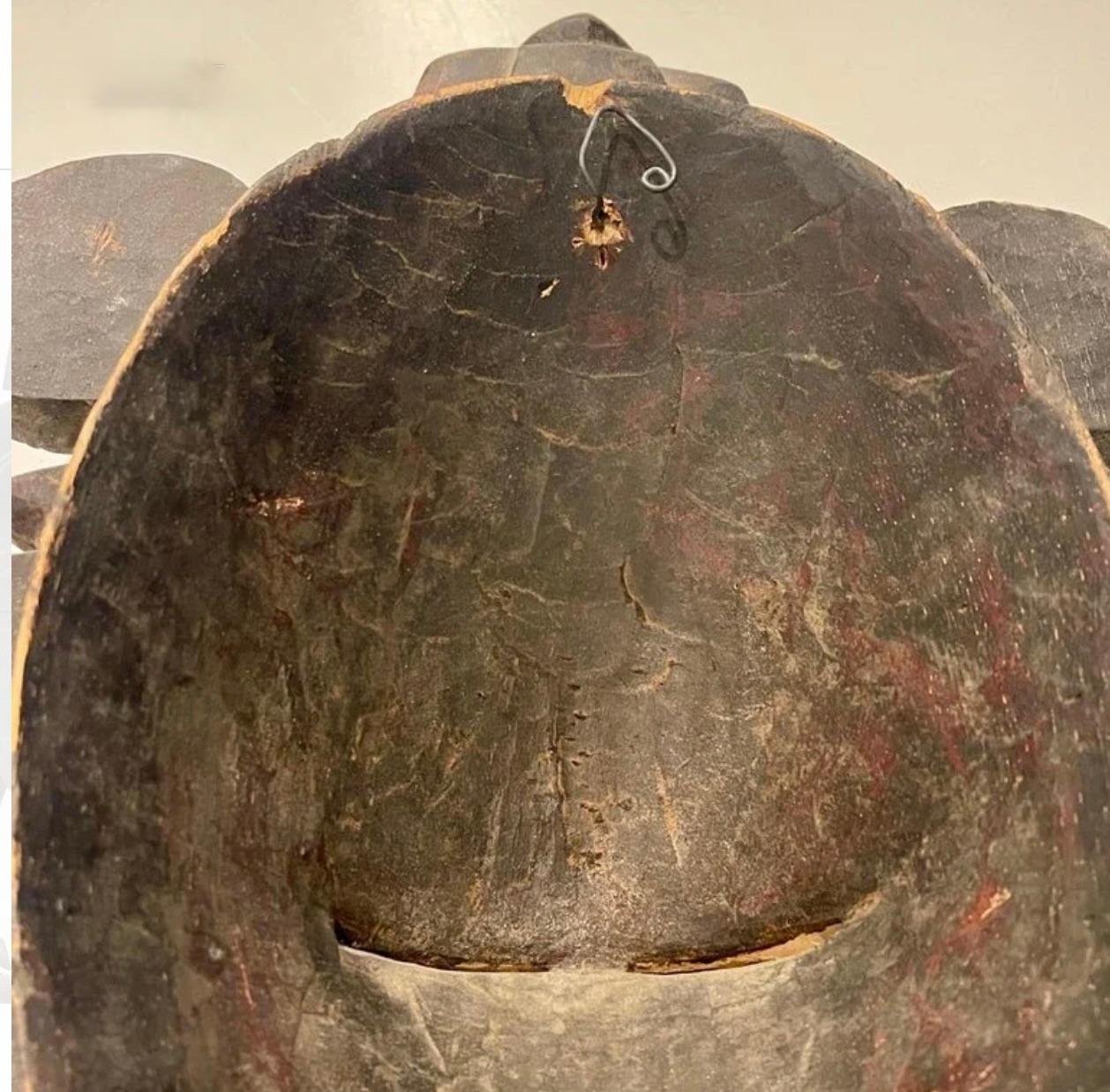 Masque rituel à la patine sombre et aux inscriptions géométriques, réalisé par le peuple sénoufo de Côte d'Ivoire. Ce masque délicatement sculpté, avec ses sourcils arqués caractéristiques, sa tête ovale et ses yeux étroits, représente un bel esprit