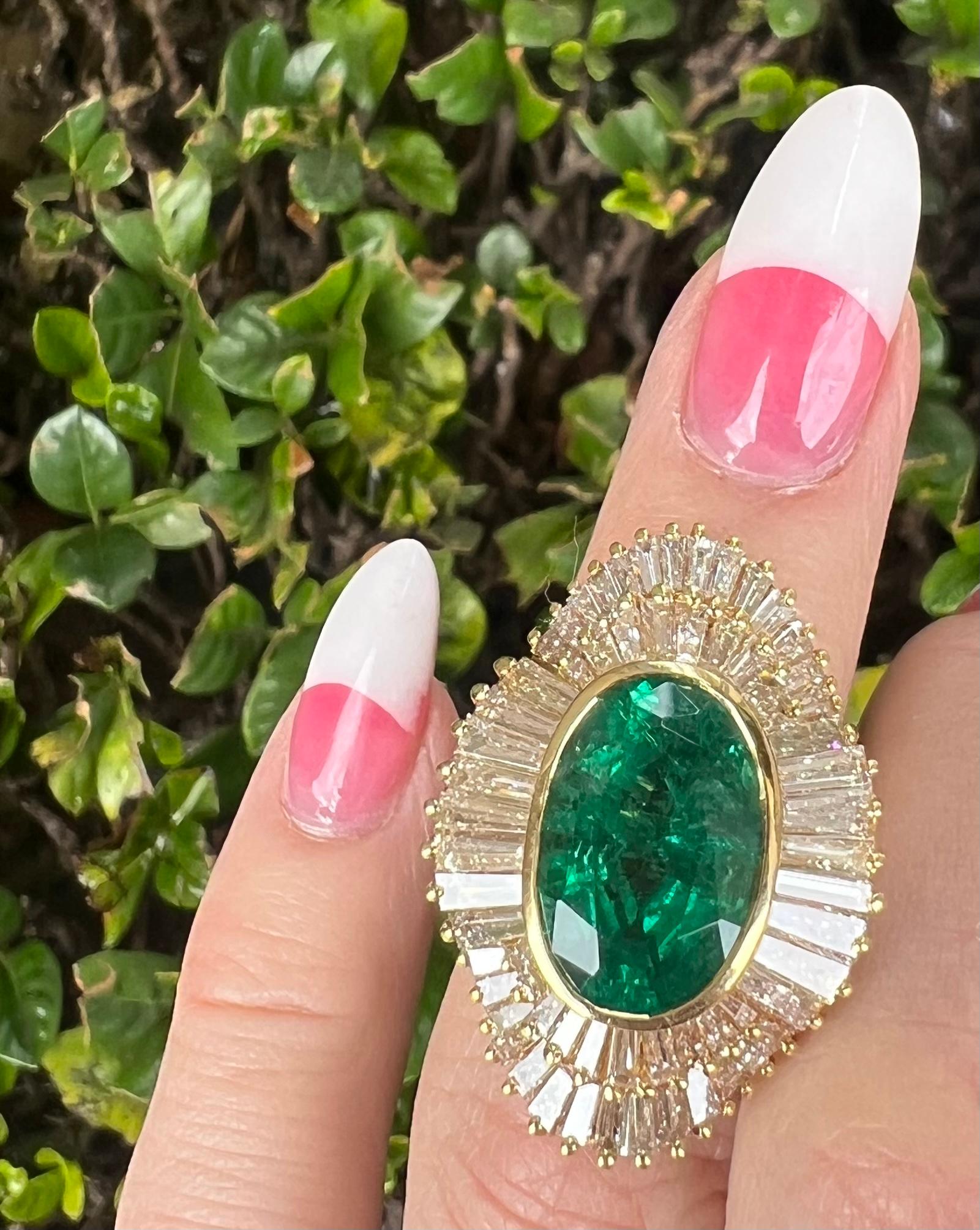 A sensational, stately and impressive 15 carat estate cocktail ring features a very large facing 9 carat oval cut natural Columbian emerald with the most beautiful vivid green color, safely bezel set and surrounded by a sparkling halo of ruffled