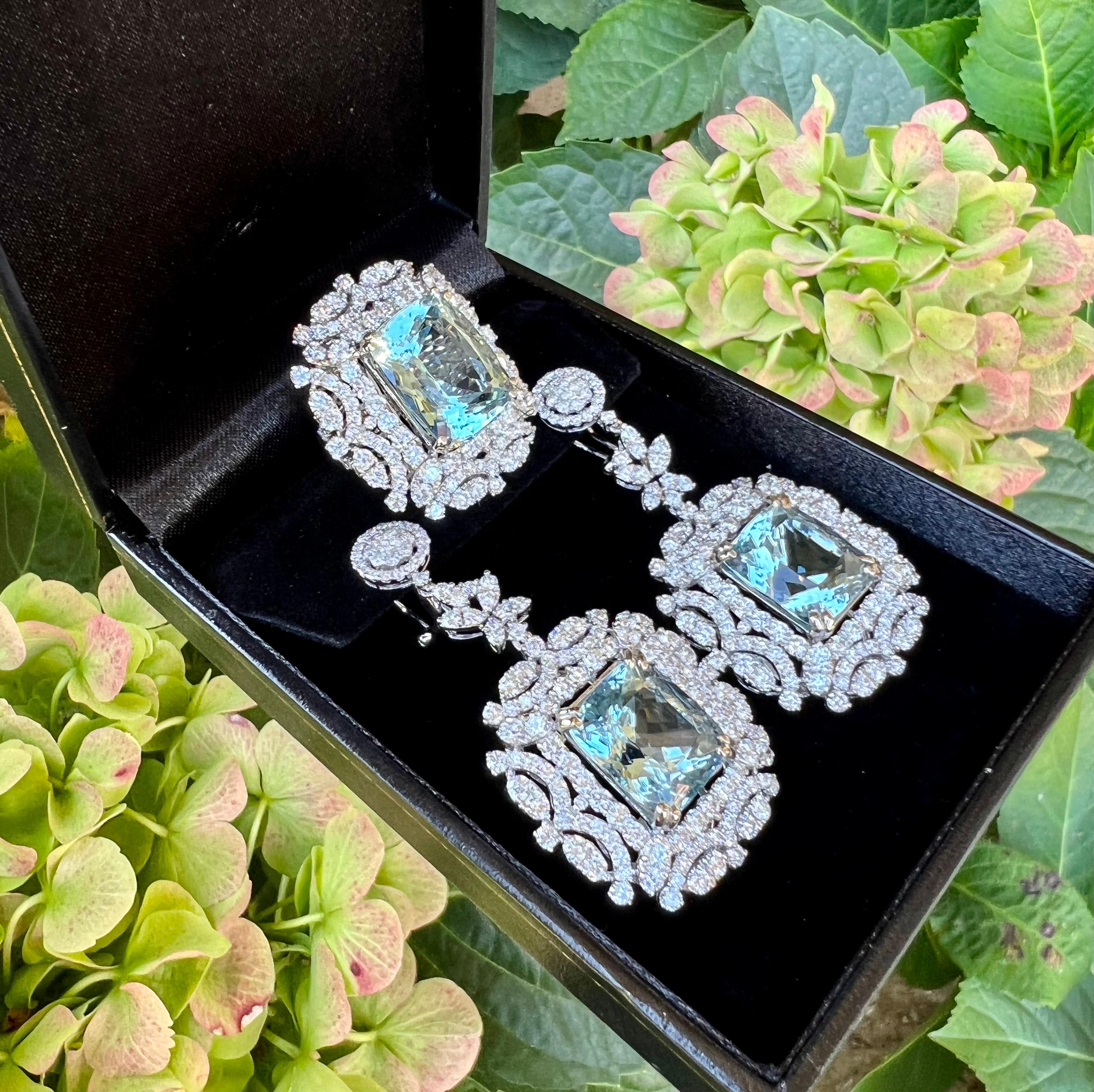A sensational and very opulent pair of drop dead gorgeous earrings feature emerald cushion cut natural aquamarines that are talon prong set in 18 karat white gold.  Each aquamarine is surrounded by a mesmerizing halo of round brilliant diamonds with