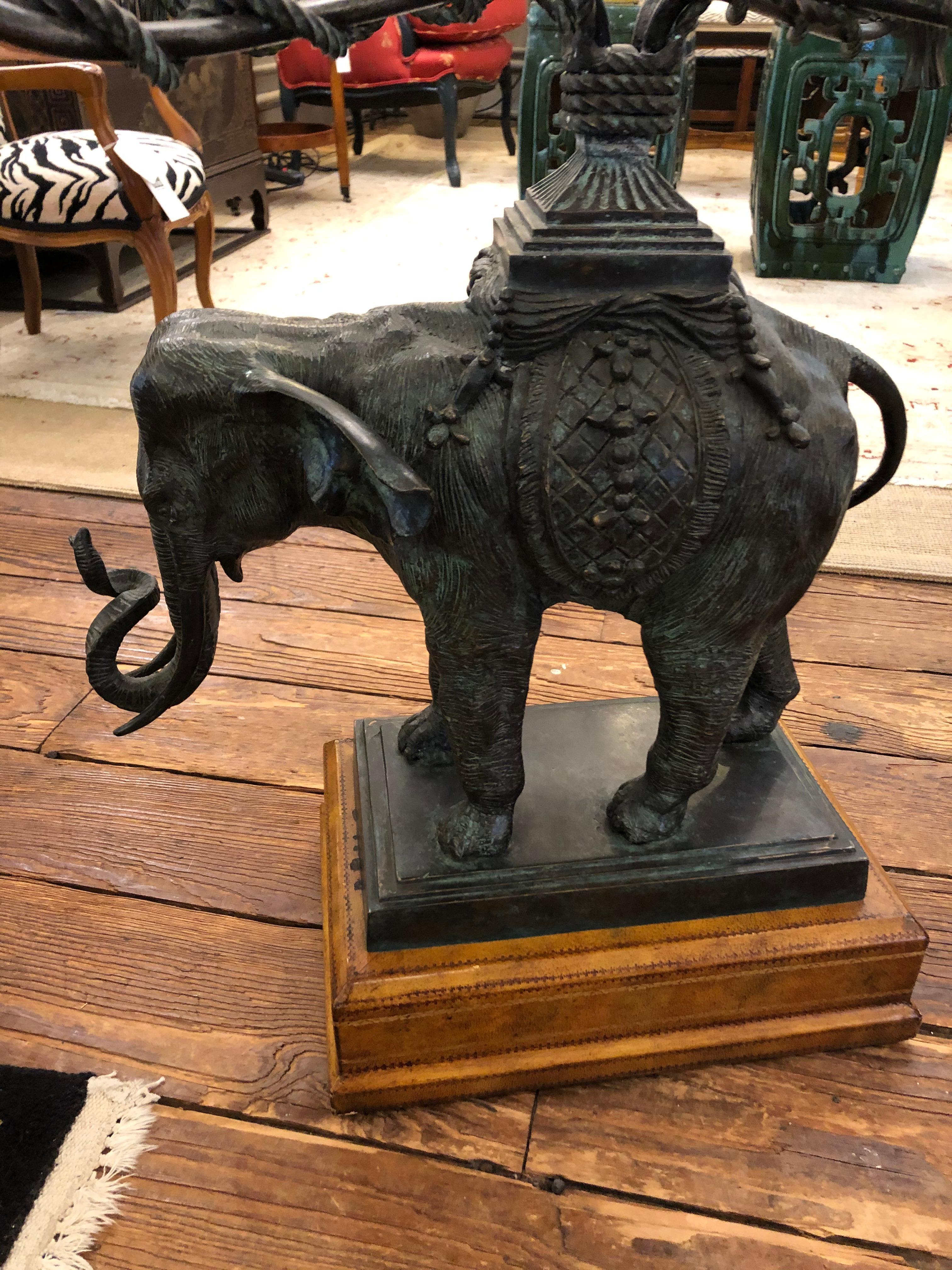 Super stylish almost square side table having sculptural patinated bronze elephant, brown tooled leather clad base and beveled glass top.