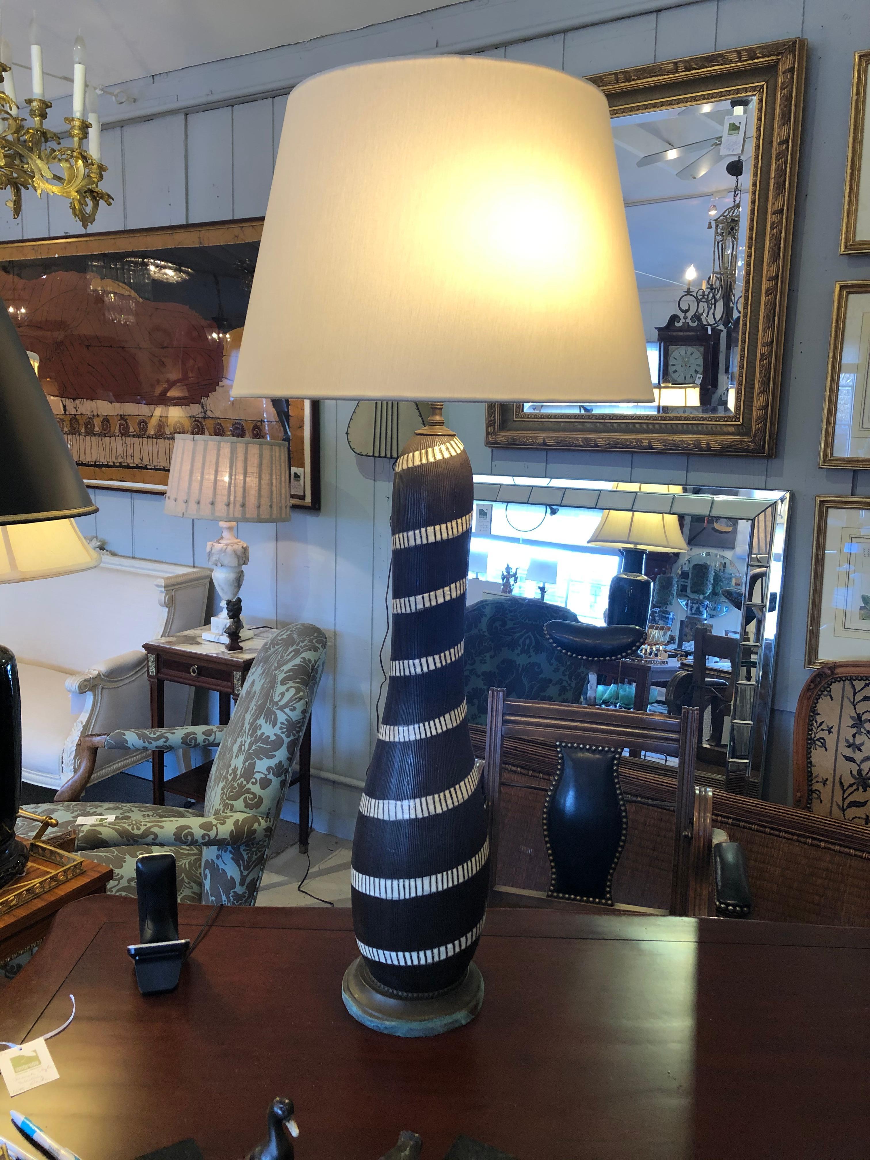 One of a kind artisan made pottery table lamp with super stylish Mid-Century Modern design having a tall elongated brown and white base with cool spiral design and hand carved lines. There's a brass base with patina and double socket. Shade not