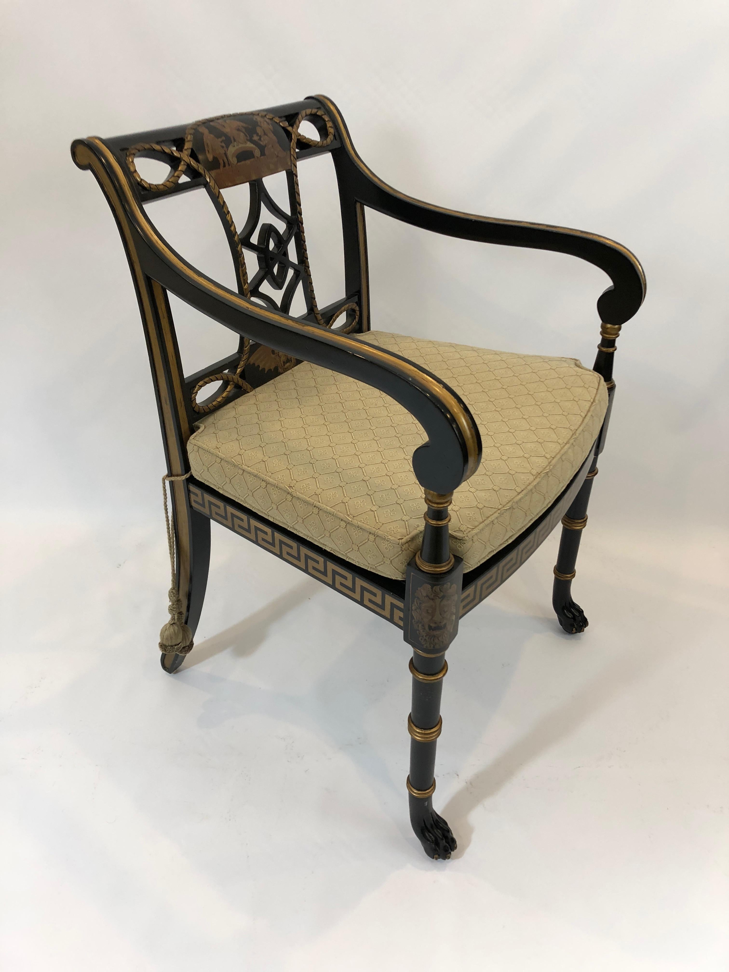 Our favorite glamorous chair in any room, a black and gold Regency style painted armchair having sensational Greek key motif, lion heads, and other adornments painted in gold with an elegantly designed open back, caned seat, and custom cushion in a