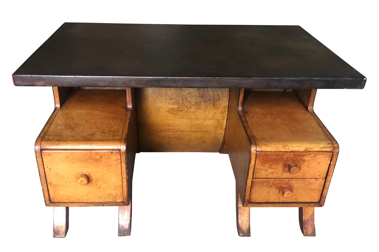 A very sensational French Art Deco desk clad in wonderful leather. Very chic and wonderful design with three drawers.