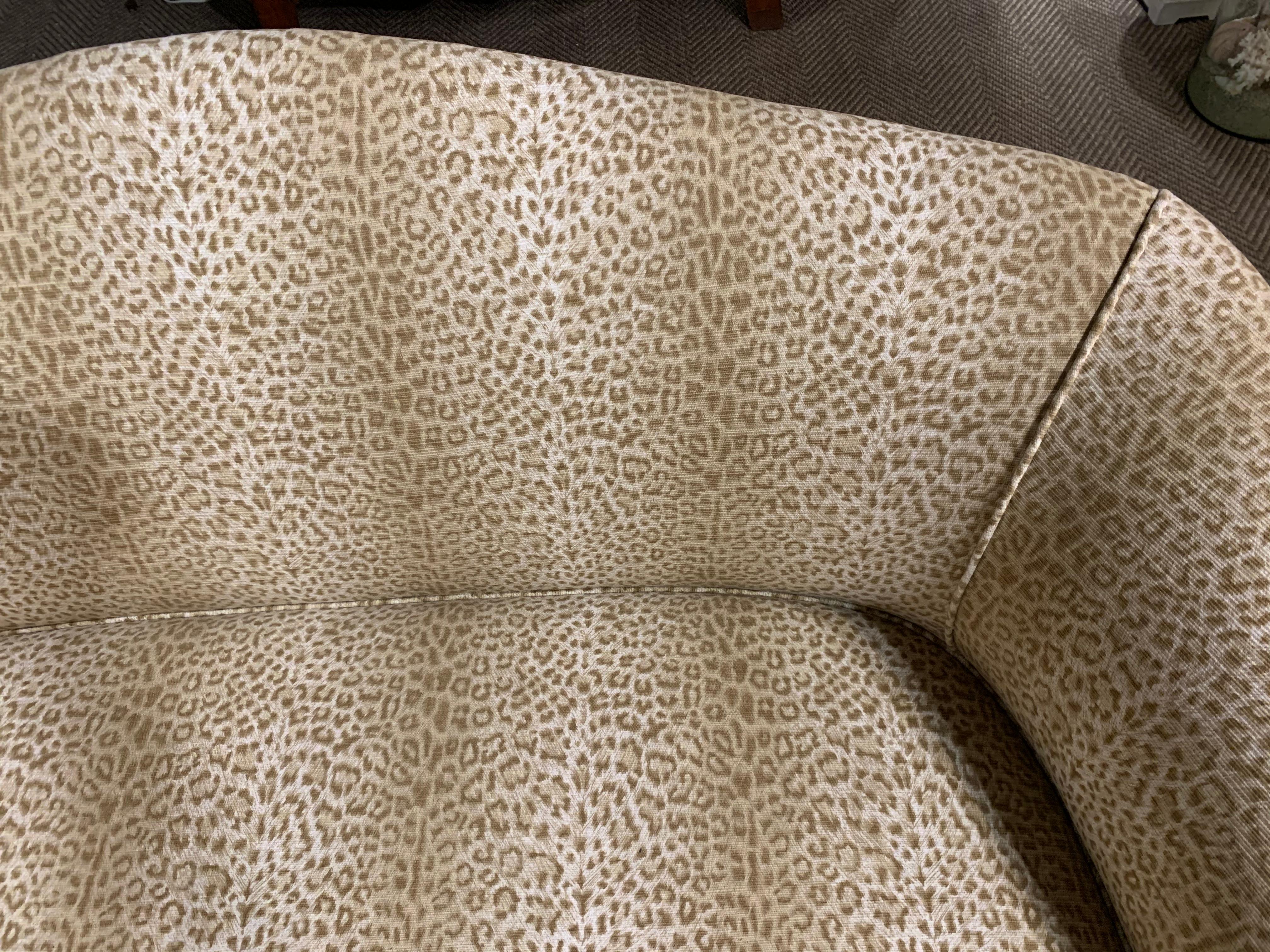 A sophisticated curvy tailored sofa having mahogany frame, carved wood on the legs, and fabulous neutral and understated animal print upholstery.

Note: A pair is available.