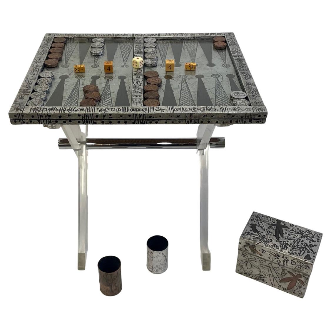 A true work of art by deceased Palm Beach artist Marvin Arenson, a sheathed metal over wood backgammon board with whimsical hand wrought repousse designs. Comes with an equally beautiful matching box with game pieces and cups. All are works of art.