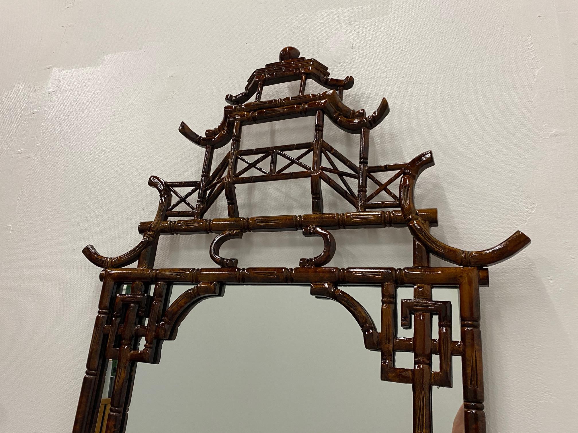 A chic Italian faux tortoise bamboo mirror having iconic multi level pagoda form at the top, Greek key design elements and wonderful rich color.