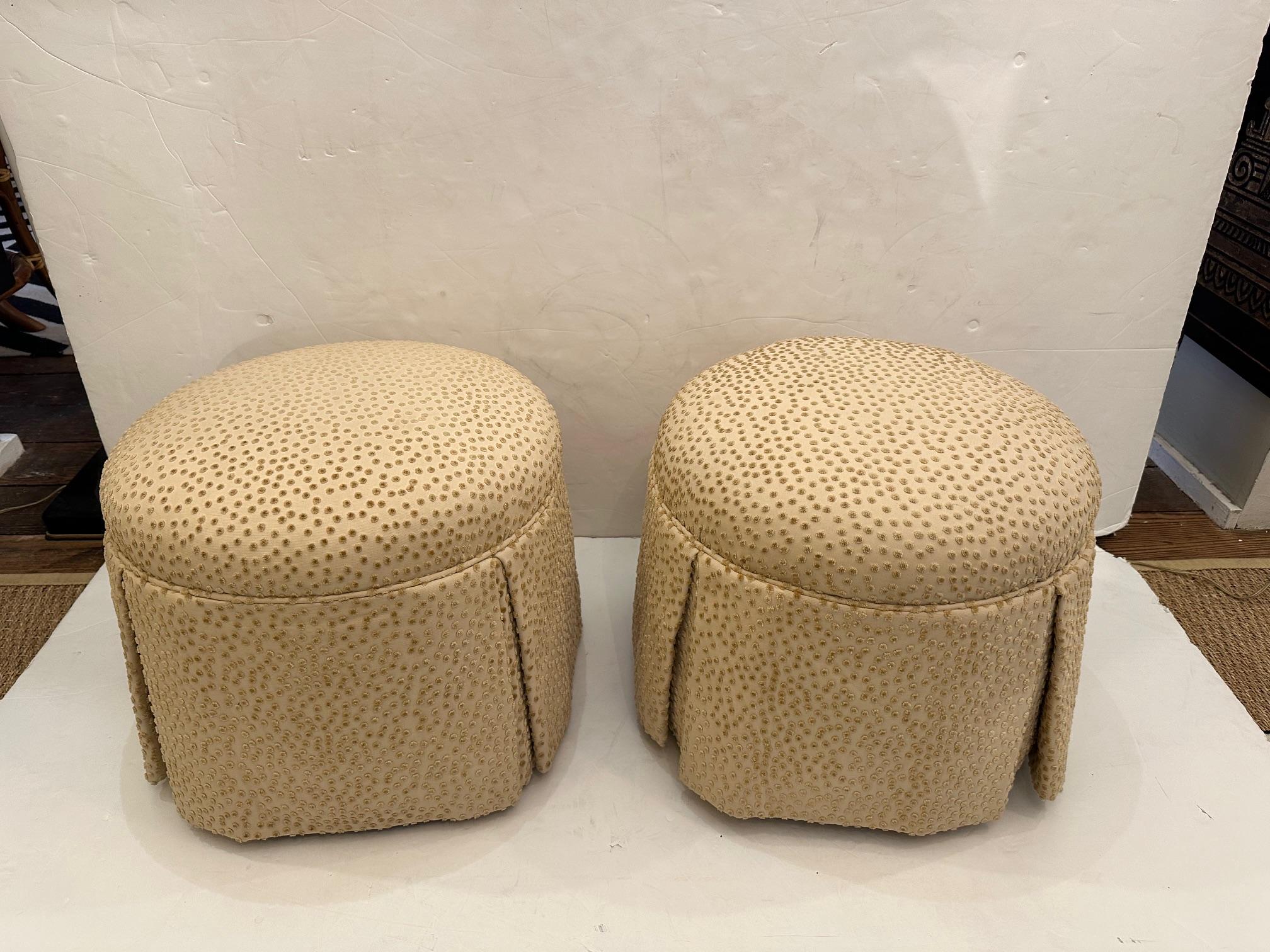 Functional and glamorous pair of round comfortable upholstered ottoman poufs having fabulous raised taupe polka dots on cream backgrounds.  The stools roll easily on casters.