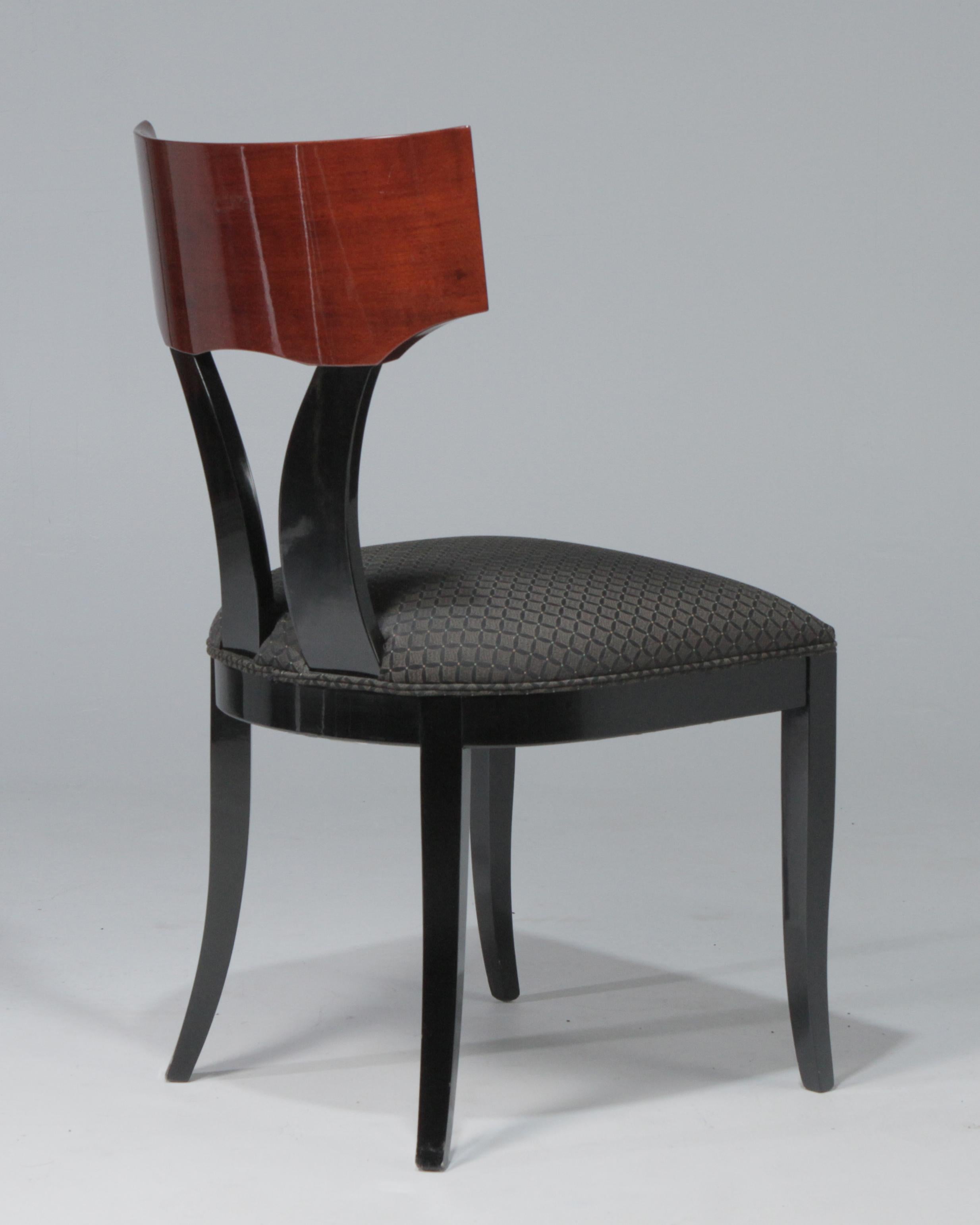 A stunning set of ten Pietro Constantini for Ello Klismos style dining chairs. The chairs are two-tone with solid black lacquer bases and clear red backs that show the wood grain, so each chair back is unique. The fabric seats are original.