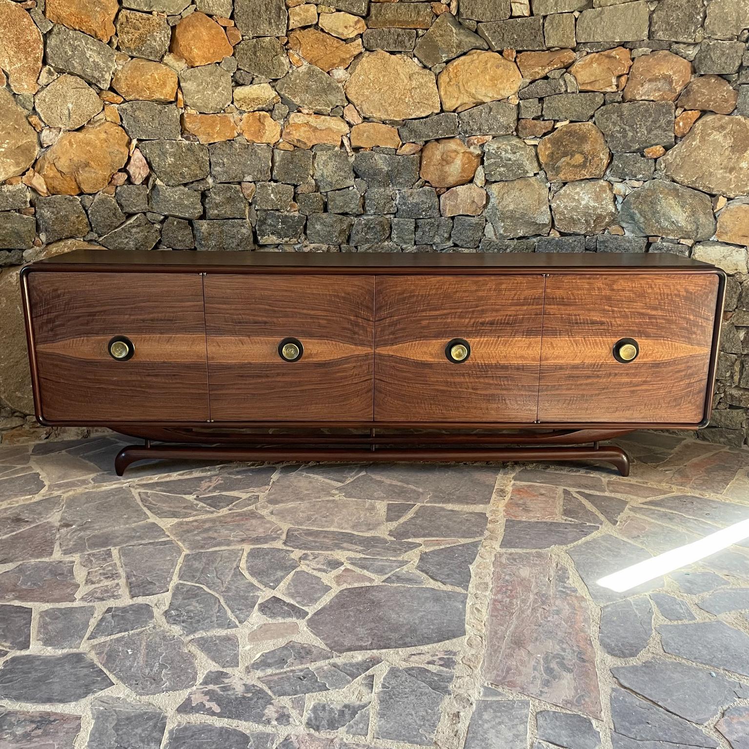 Credenza
Sensational Style of Frank Kyle Custom Credenza Mexico City 1950s
Richly grained wood presentation. Dynamite curves. Sculptural solid mahogany legs.
Cabinet in mahogany and exotic woods with round bronze hardware.
Includes set of pullout