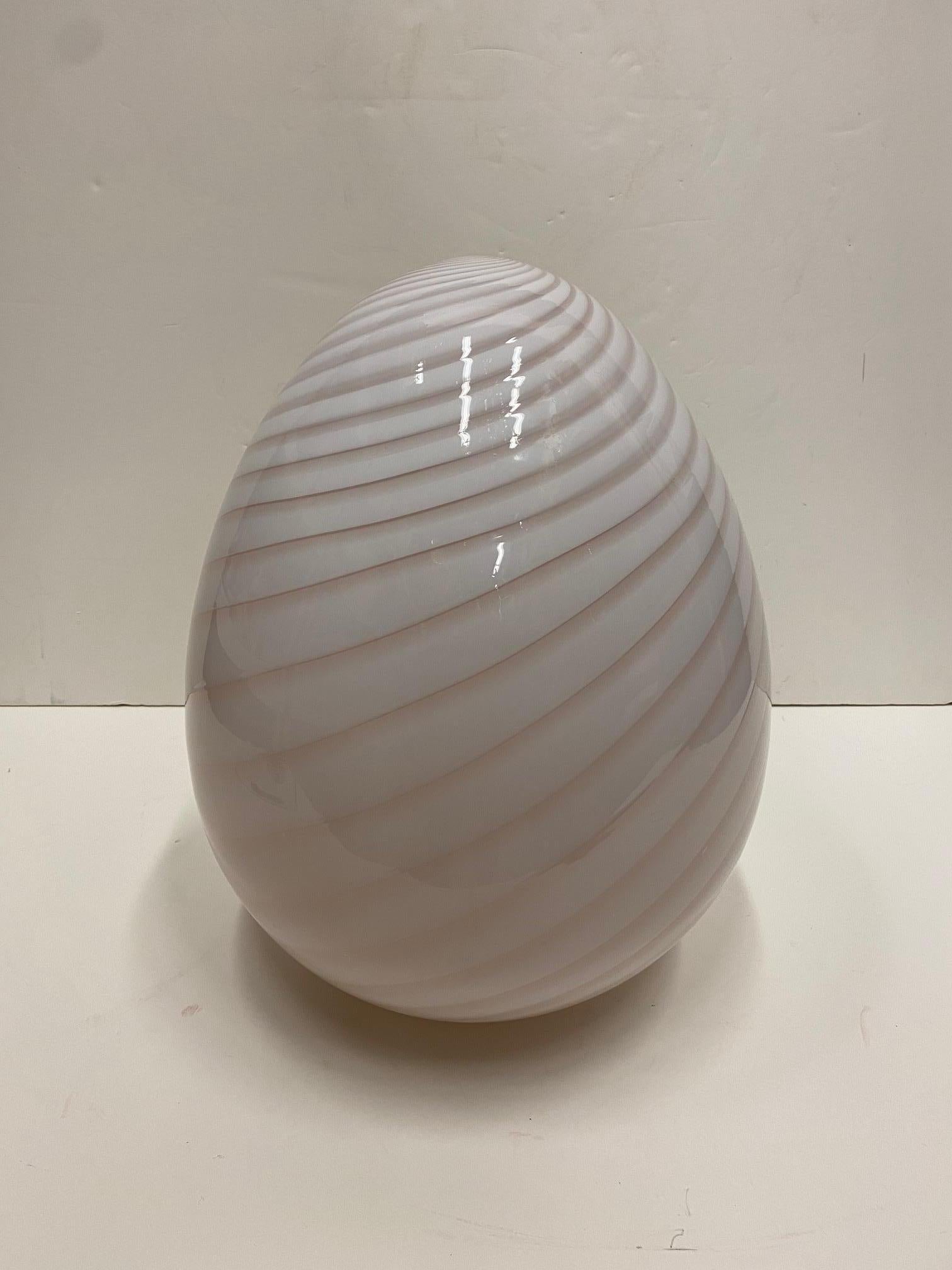Gorgeous table light by Fulvio Bianconi for Venini in the sensual shape of an egg having spiral lines in the glass. When lit the lamp has a romantic pink cast. 

Note: A second slightly smaller egg lamp is also available.