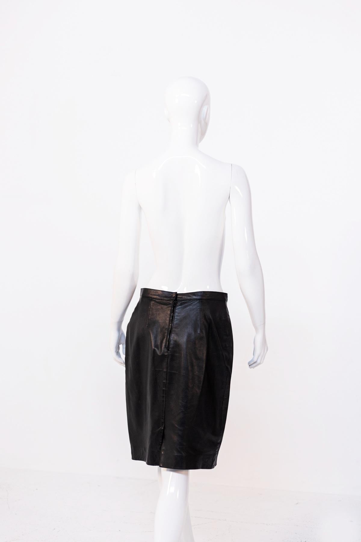 Sexy gonna in pelle vintage disegnata negli anni '90, realizzata in Italia.
La gonna è uniforme nella lavorazione e nel colore, una sensuale pelle nera.
La gonna è composta da una sottile fascia sui fianchi, dove la gonna è impreziosita da due
