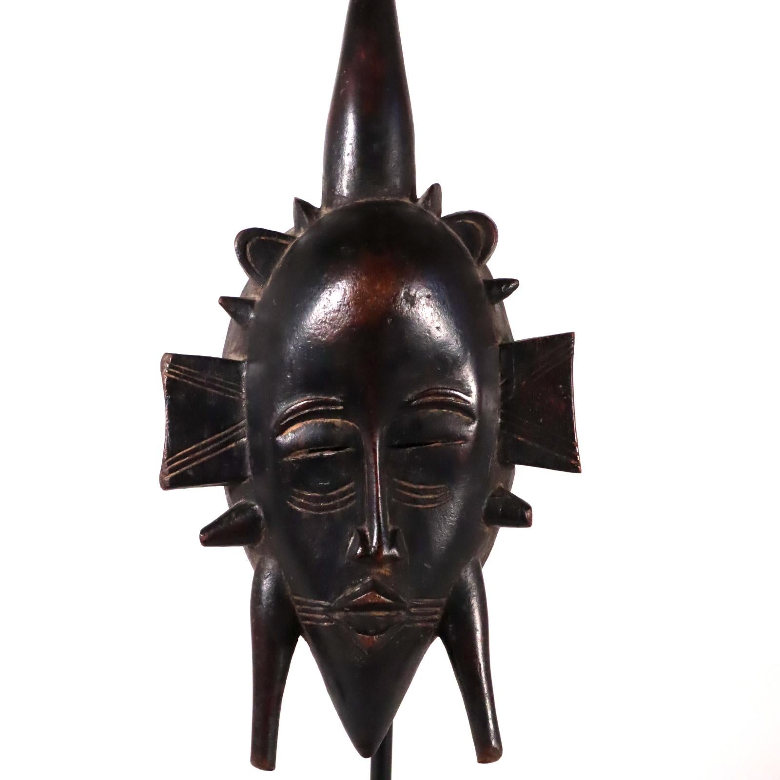 A simple and elegant face mask from the Senufo people of West Africa. The Senufo live in areas that are parts of Mali, Ivory Coast (Cote d'Ivoire) and Burkina Faso. Created in the early to mid-20th century. Hardwood with a black patina, rubbing and