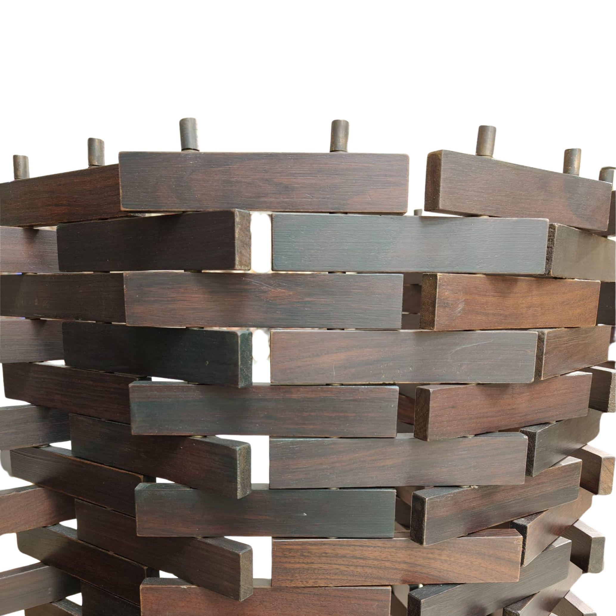 Separè realizzato in legno di teak, composto da circa 560 elementi uniti mediante perni metallici. Le estremità dei perni sono rifinite con pomoli in ottone che completano la struttura e ne definiscono il sistema di assemblaggio. L'oggetto è di