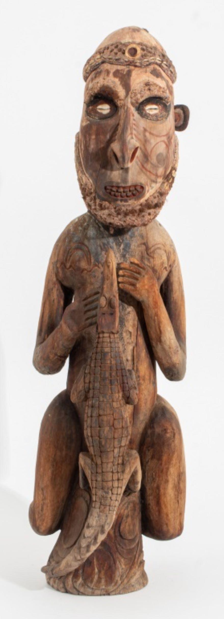 Papua New Guinea Sepik River Carved and Polychromed Wood Male Figure with Crocodile Sculpture, the man with inset cowrie shell eyes. 33