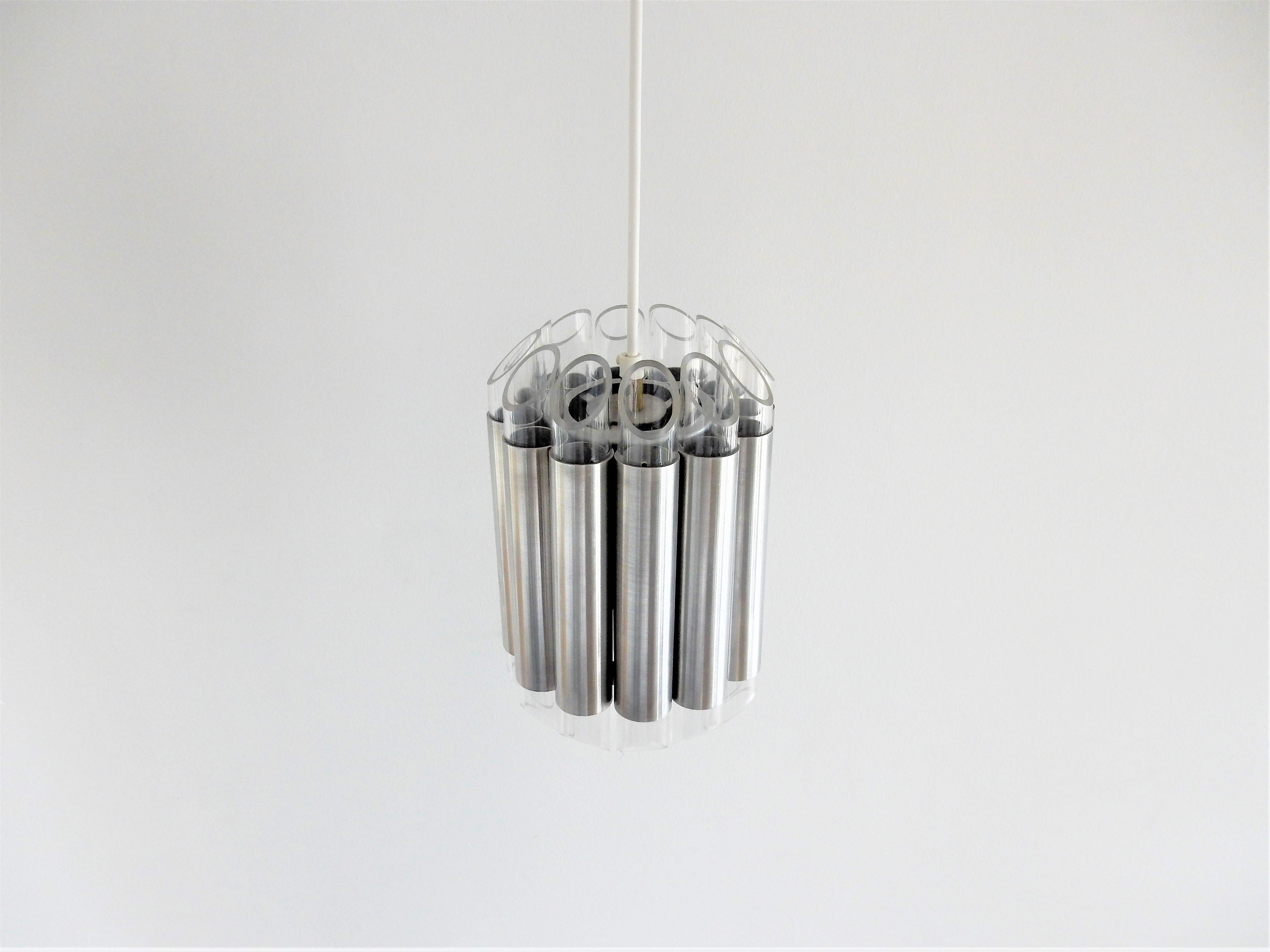 This stunning 'Septiem' pendant lamp was designed by RAAK Amsterdam in the 1960s. The light source is surrounded by aluminum and acrylic tubes. The tubes have polished facets on both ends that diffuse and spread a beautiful and mysterious light.