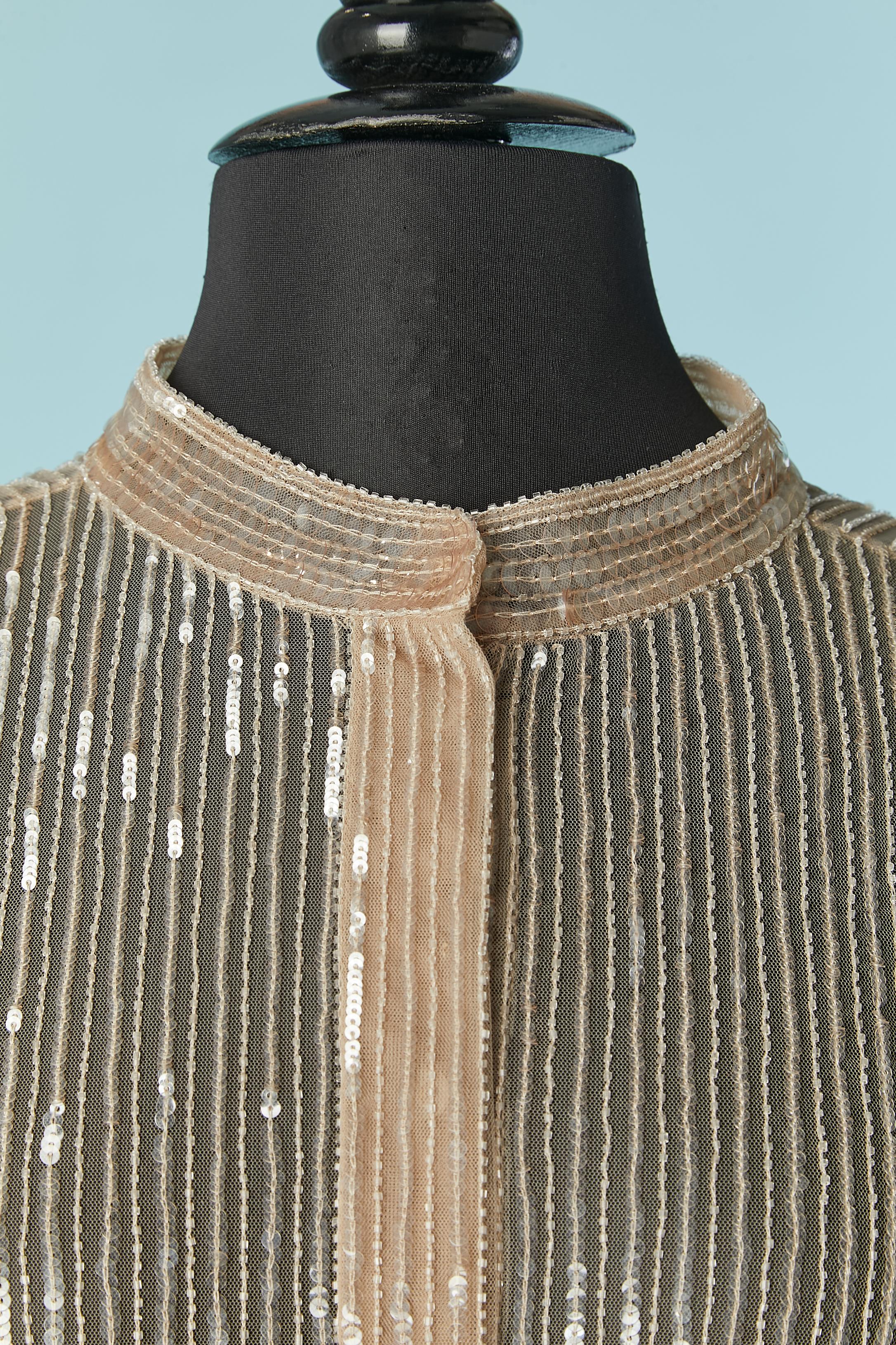 Camicia di paillettes (PVC) e perline (perle di vetro) su una base di tulle trasparente (100% poliammide) 
Chiusura a scatto sui polsini. 
TAGLIA 44 (It) 40 (Fr) 8 (US) 