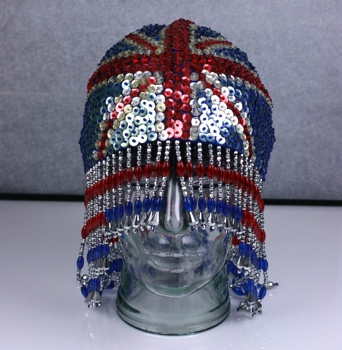 An English patriot surfaces at the disco (circa 1970's), translated in sequins and glass beads on a blue jersey base.
Best paired with royal blue spandex and white roller skates. 1970s UK. Excellent condition.
Measure of lower edge 20