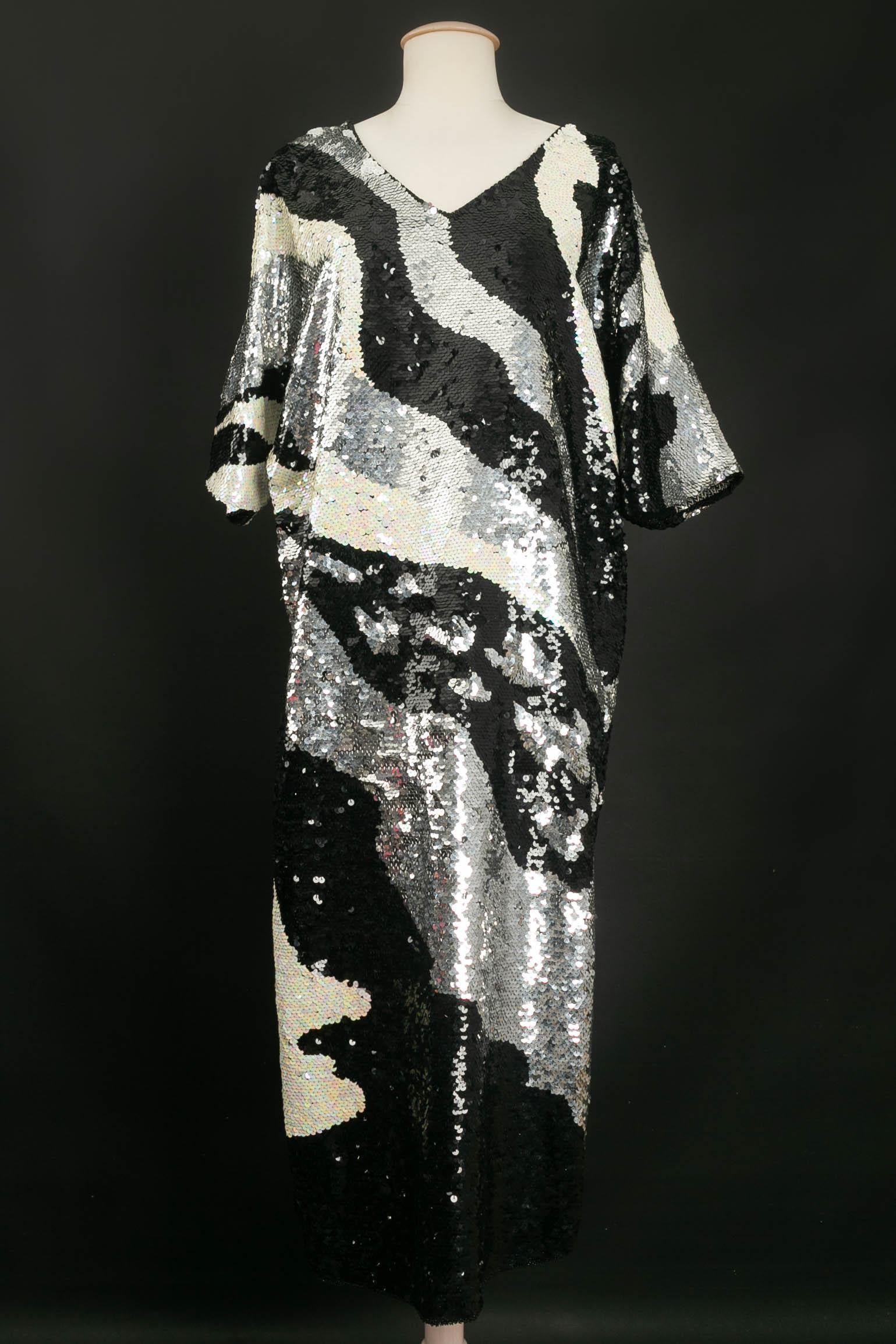 ANONYMOUS -Kleid komplett mit silbernen, schwarzen und weißen Pailletten bestickt. Es ist an den Seiten bis zur Höhe der Hüfte geschlitzt. Unsigniertes Stück. Kein Größen- oder Zusammensetzungsetikett, es passt zu 38FR/40FR.

Bedingung:
Sehr guter