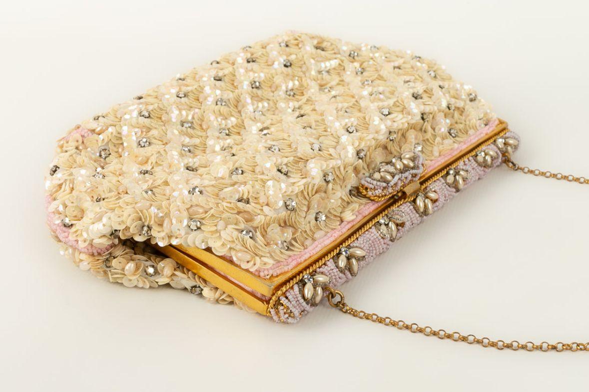 Small sequinned bag in beige and pink tones from the 1960's.

Additional information: 

Dimensions: 
Width: 20 cm, Height: 14 cm, Depth: 3 cm, Handle: 30 cm

Condition: Good condition
Seller Ref number: S151
