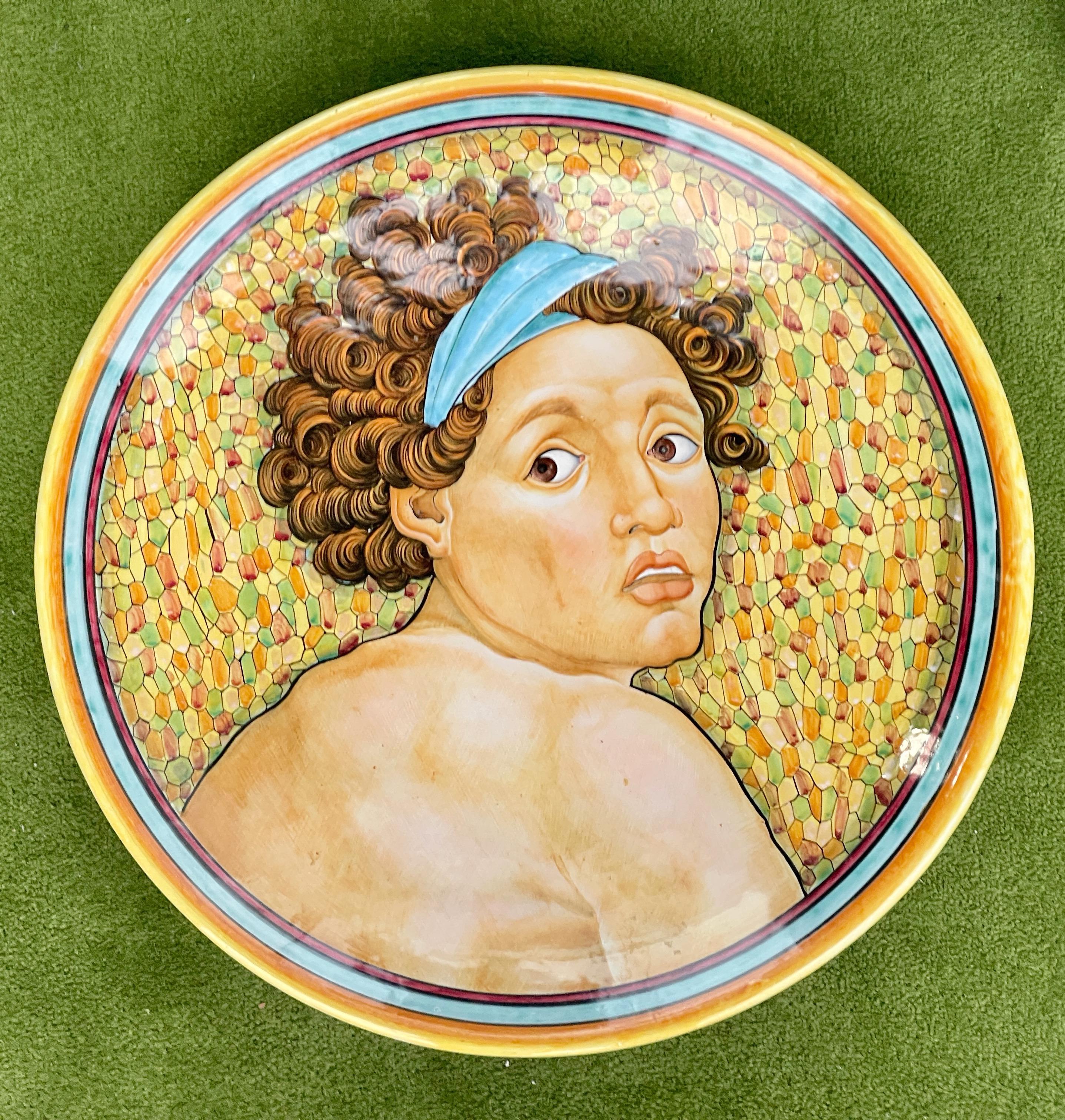 Deruta majolica charger from the workshop of Serafino Volpi hand painted with the wide eyed curly haired head of an 'ignudo' figure wearing headband from Michaelangelo's Sistine Chapel ceiling. On the back it is somewhat illegibly signed by the