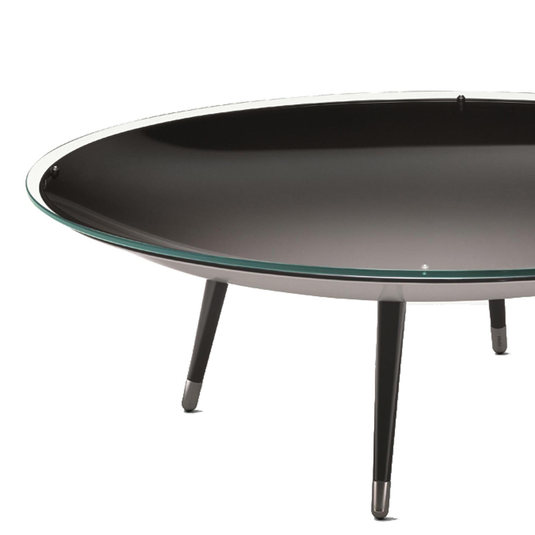 Coffee table serail smocked with clear glass top
on a concave base in curved mirrored glass, 10mm
thickness, base with smocked ground. Underside of 
base in silver paint finish. With 4 legs painted in black 
with brushed steel feet. Concave base